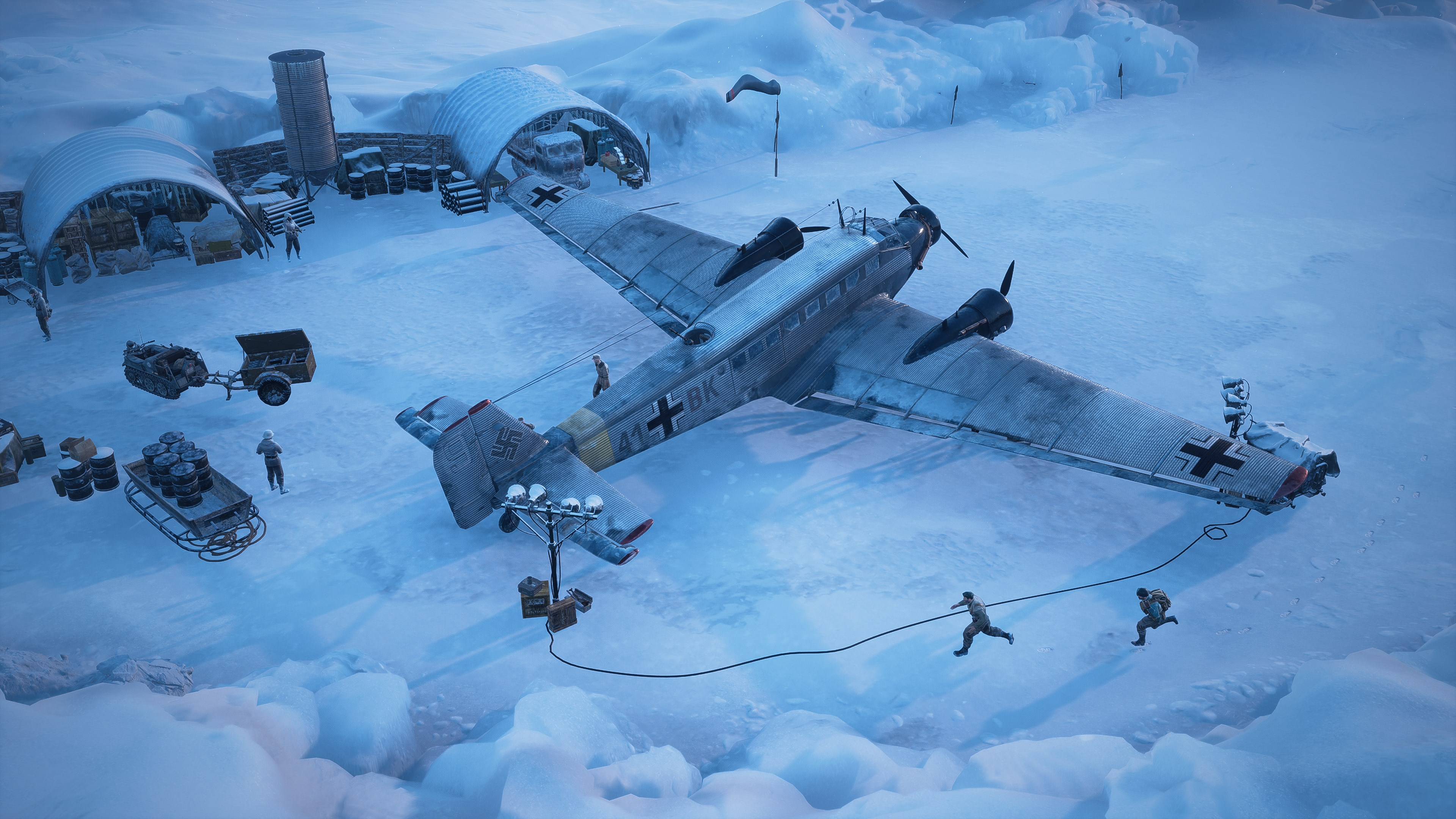 Vue aérienne d'un avion de transport de l'époque de la Seconde Guerre mondiale sur la glace, entouré de soldats et d'équipement.