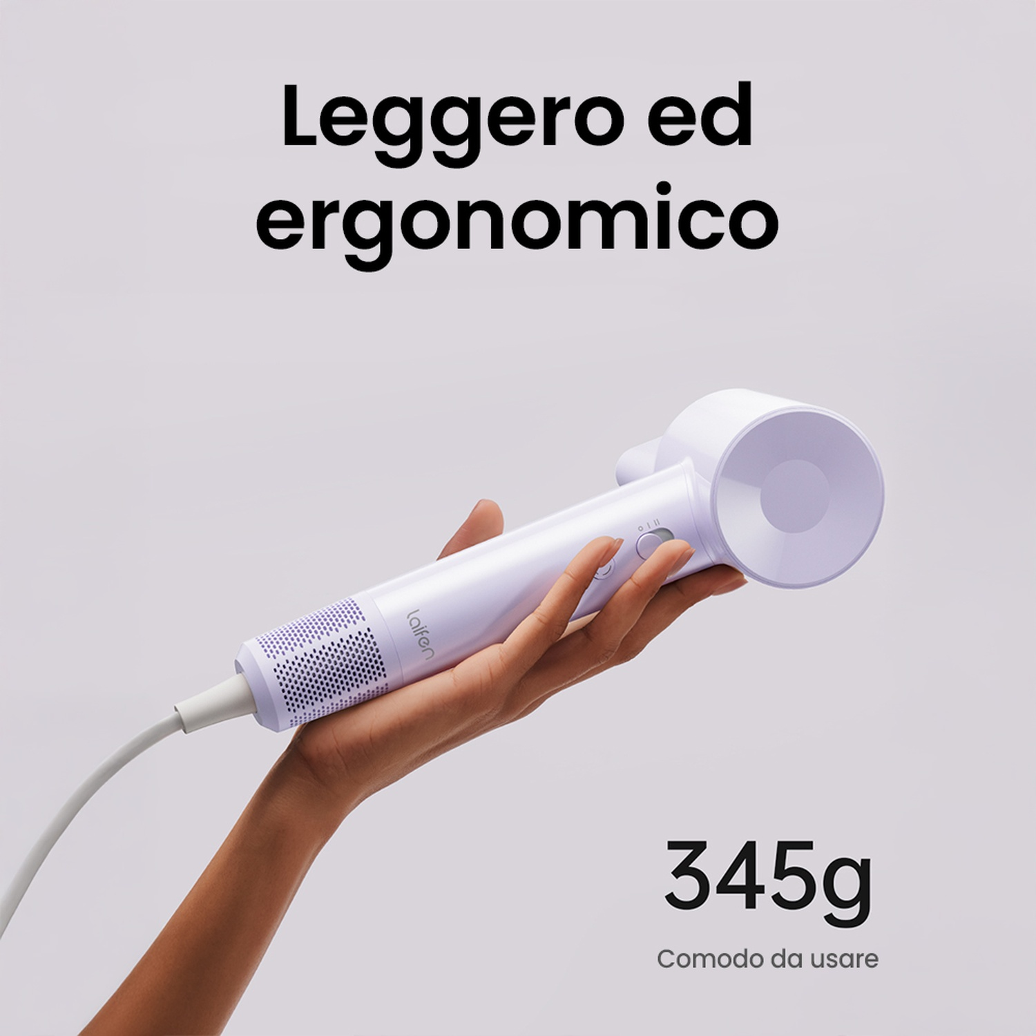 Mano di donna che tiene un asciugacapelli bianco. L'asciugacapelli ha bottoni e una griglia, con 345g scritto sotto.