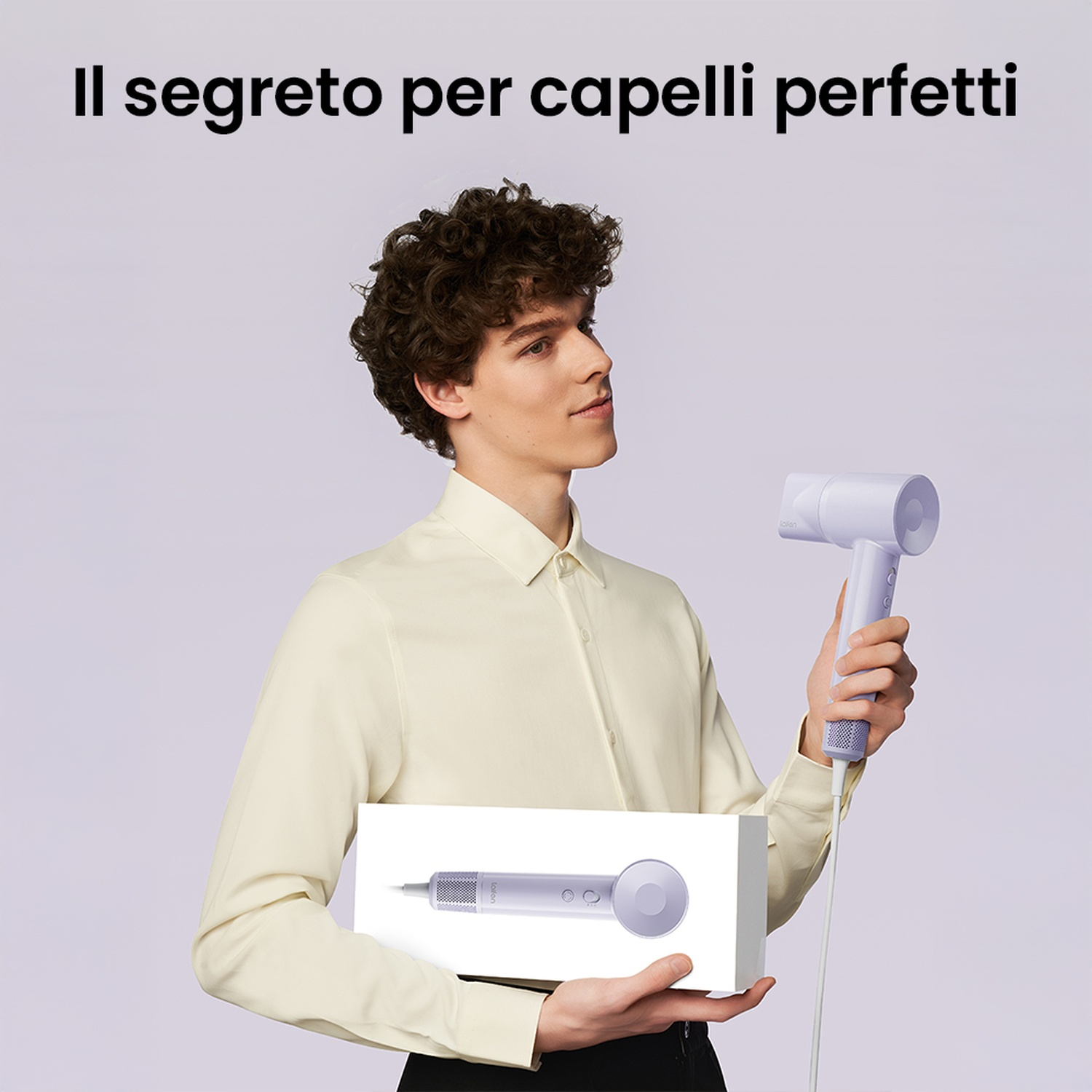 Uomo che tiene una scatola bianca con un asciugacapelli. L'asciugacapelli è viola. Il testo dice 'Il segreto per capelli perfetti'.