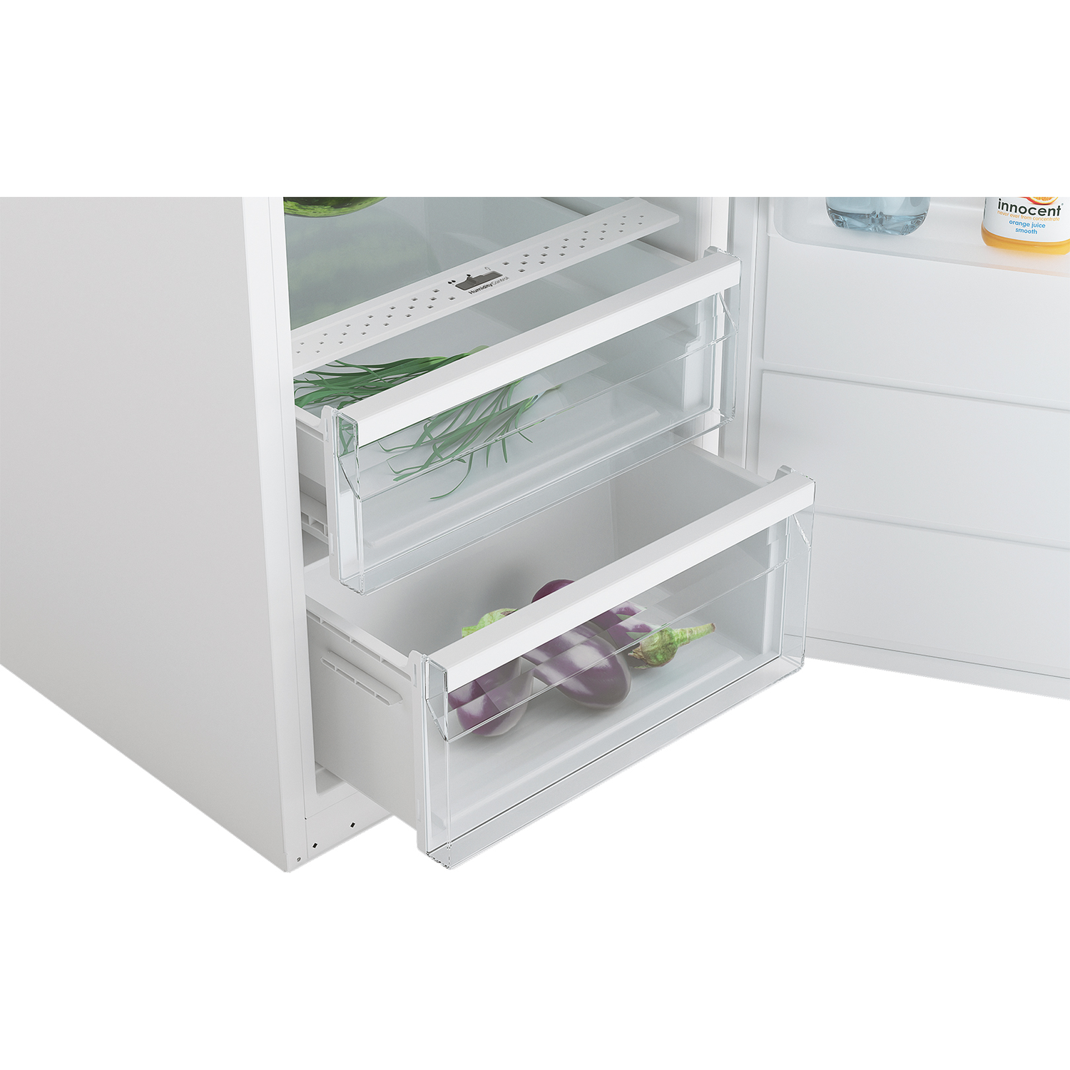 Witte koelkast binnenkant. Twee laden met groenten. Open deur. Innocent-sapfles.