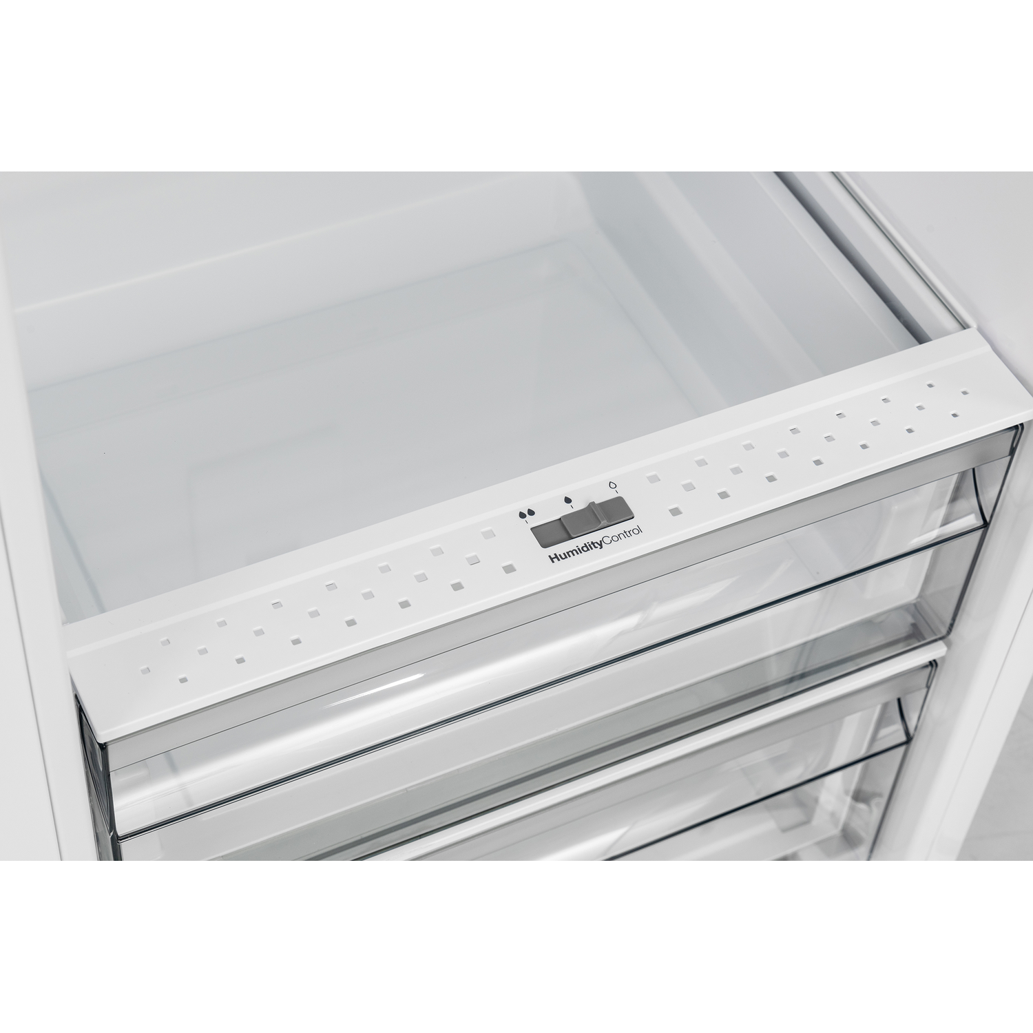 Een open koelkast met glazen planken. De bovenste plank heeft een wit frame met 'Humidity Control'.