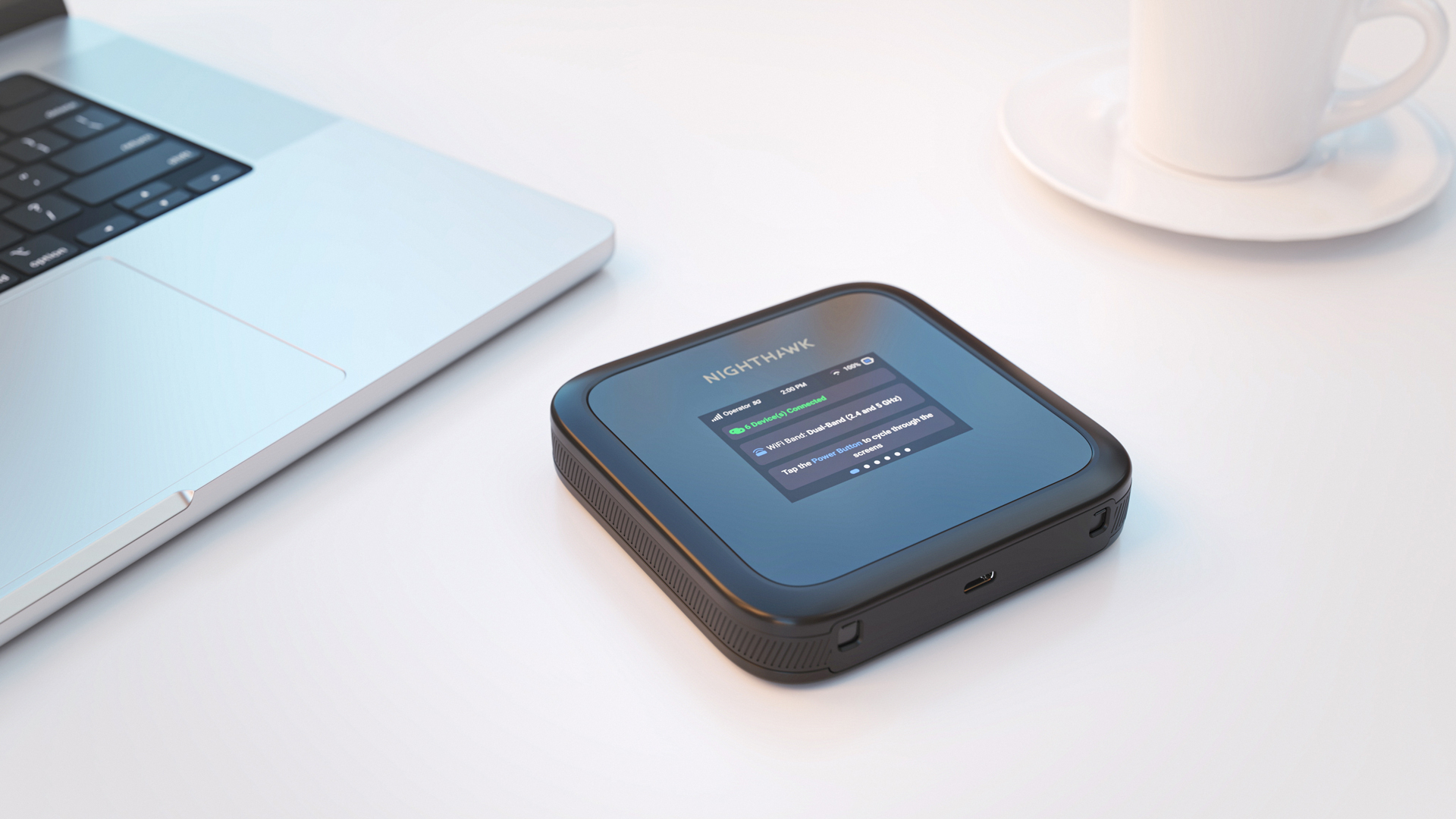 Ein schwarzer und grauer Router und ein Laptop auf einem weißen Tisch.