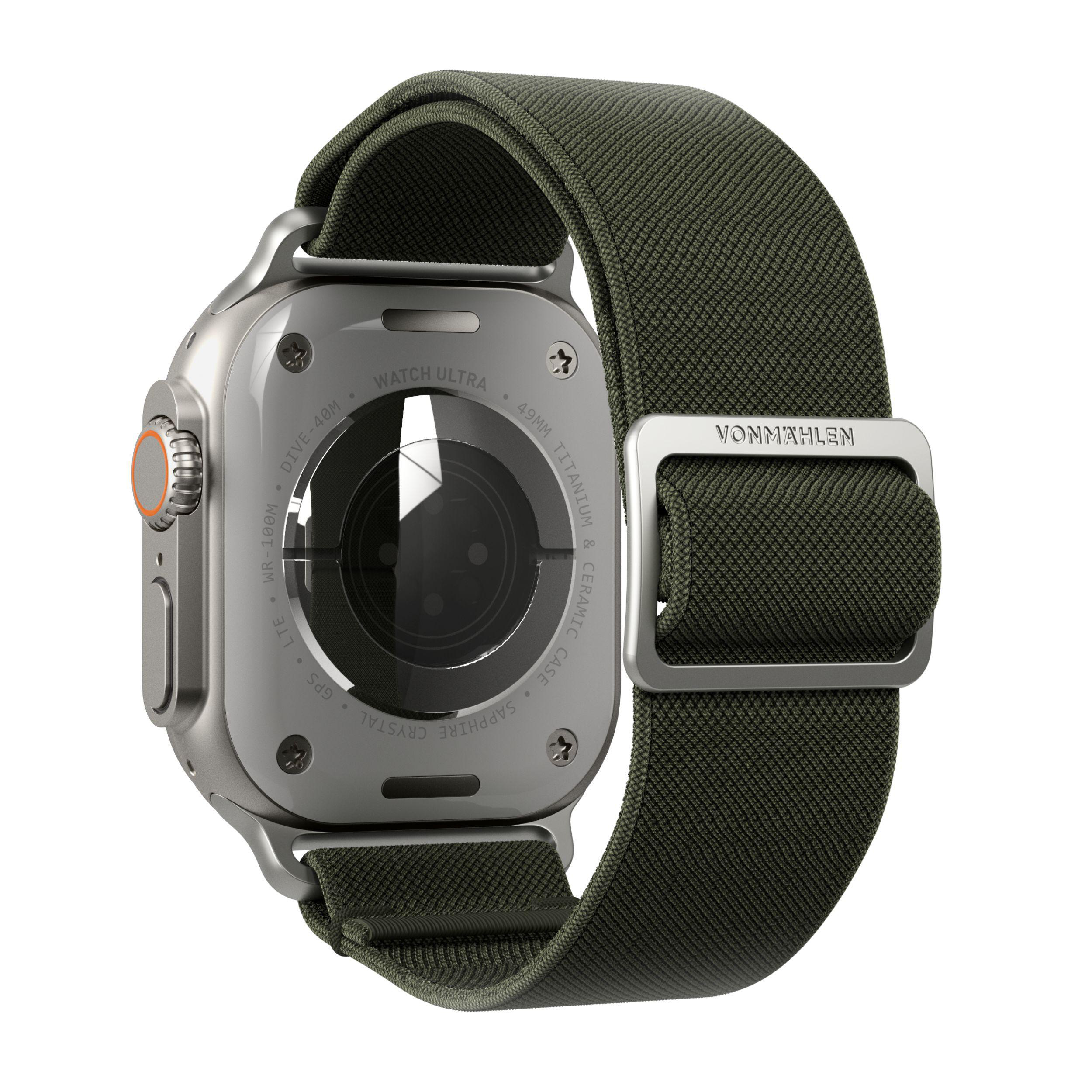 Eine silberne Apple Watch mit grünem Armband, von hinten gesehen. Die Rückseite hat Text und einen Sensor.