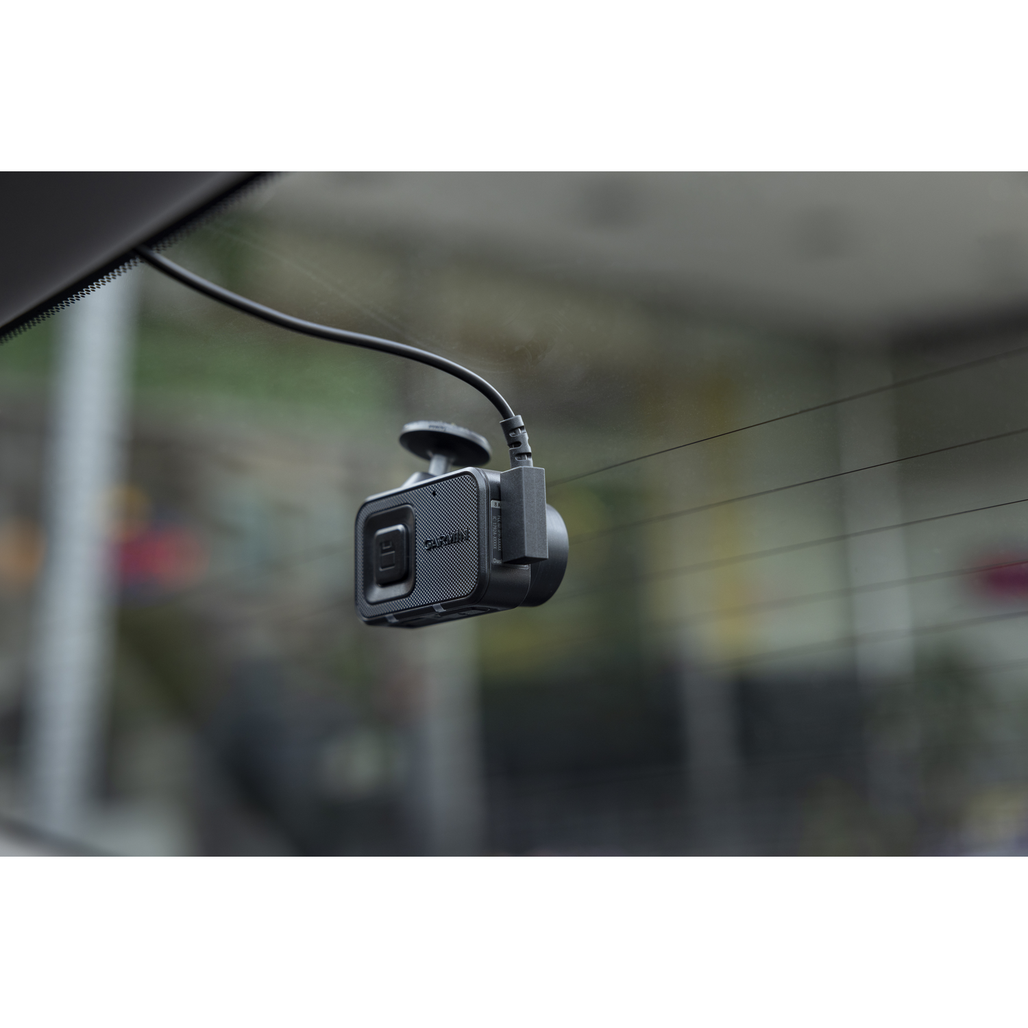 Een autodashcam is op de voorruit gemonteerd. De camera is zwart.