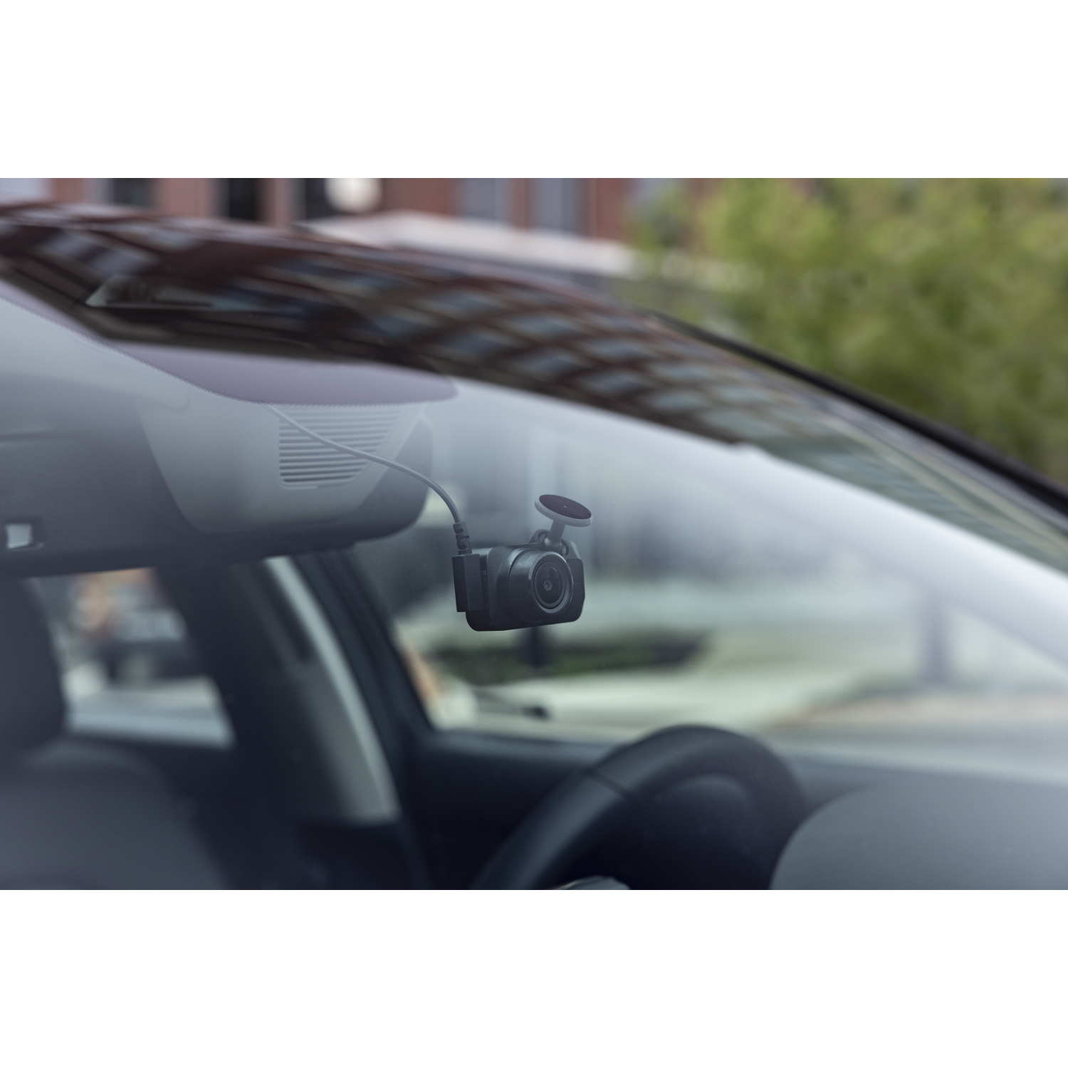 Zwarte auto dashcam gemonteerd op een voorruit. De camera is naar voren gericht.