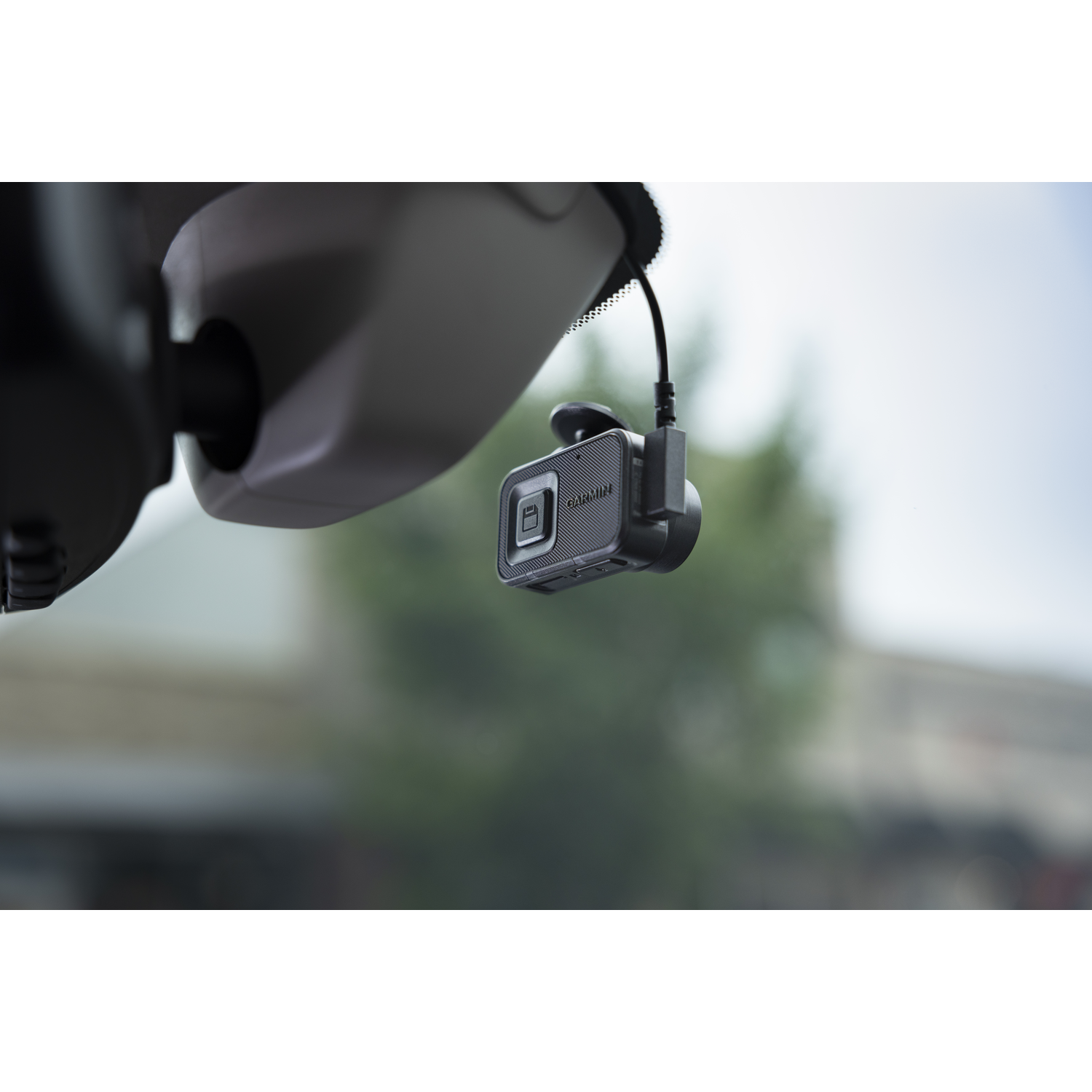 Dashcam op voorruit. Zwarte kabel verbindt hem, weg zichtbaar.