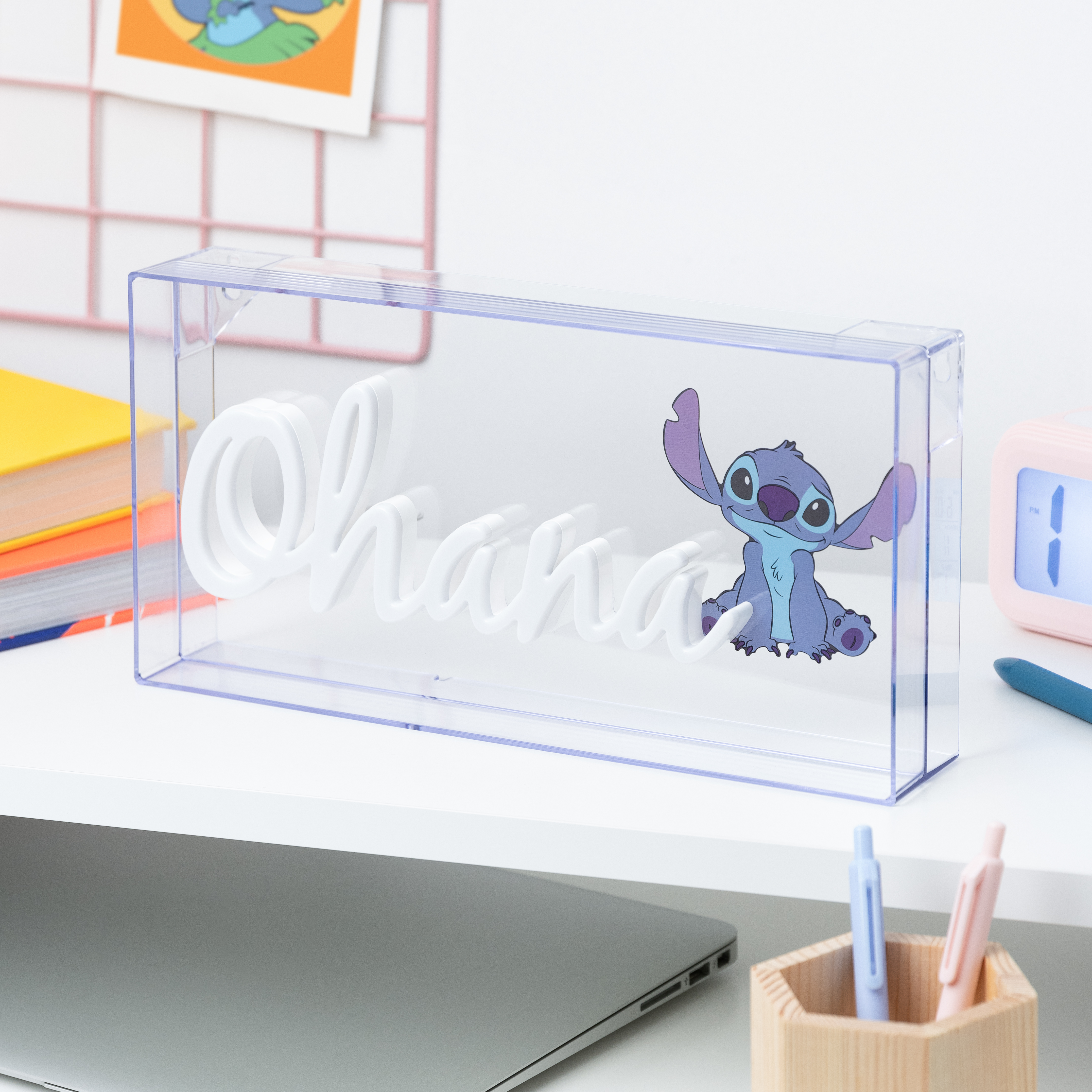 Transparente Plastikbox mit 'Ohana' und Stitch-Illustration auf weißem Schreibtisch.