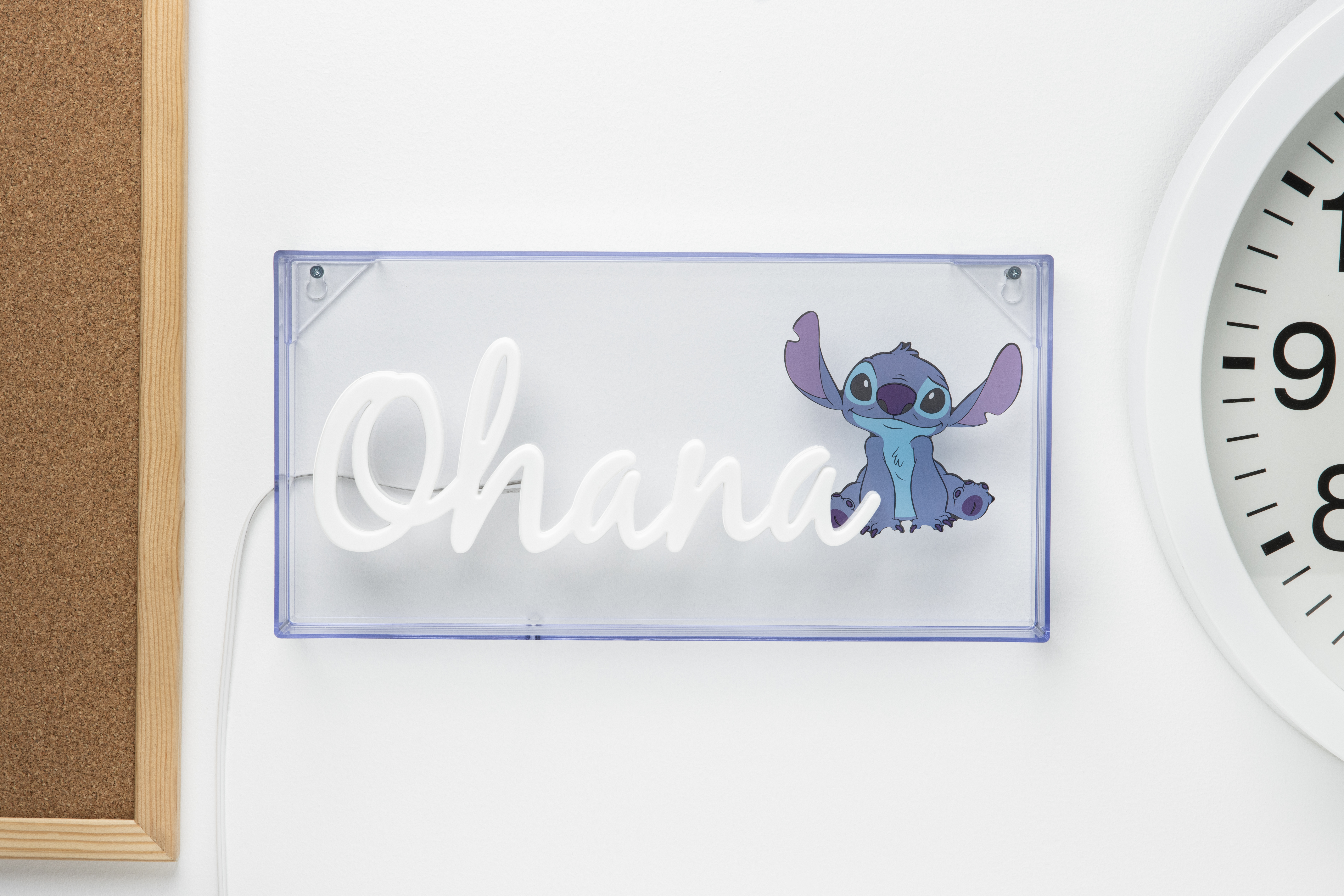 Neonschild mit 'Ohana' und Stitch-Illustration an einer weißen Wand.