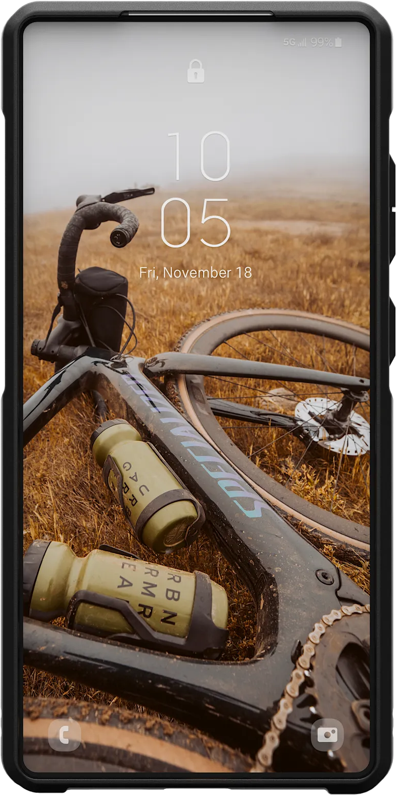 Un smartphone sur un champ avec un vélo tombé. L'écran affiche la date et l'heure.