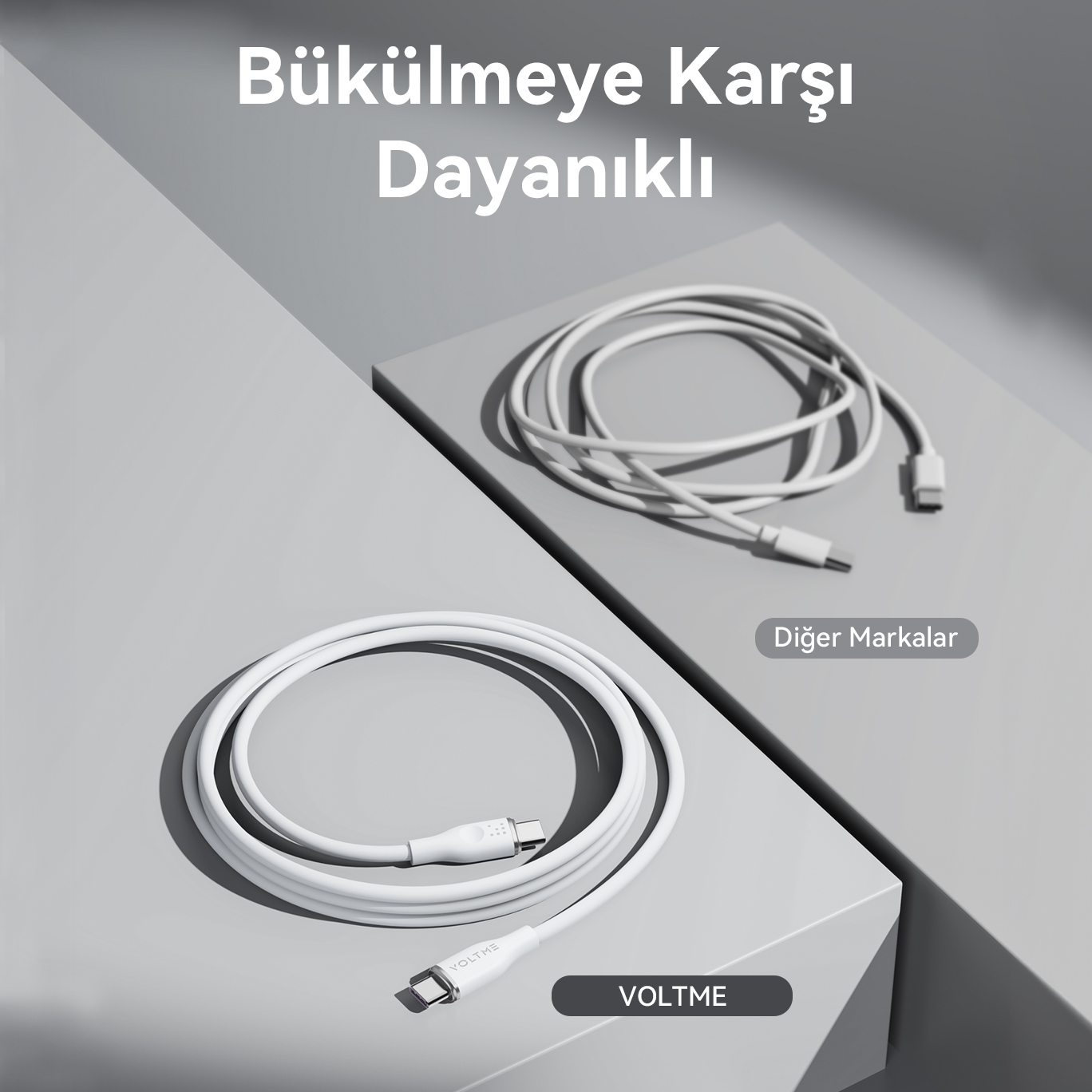 Beyaz şarj kabloları, biri kıvrılmış, biri düz, gri bir yüzeyde metinle gösteriliyor.