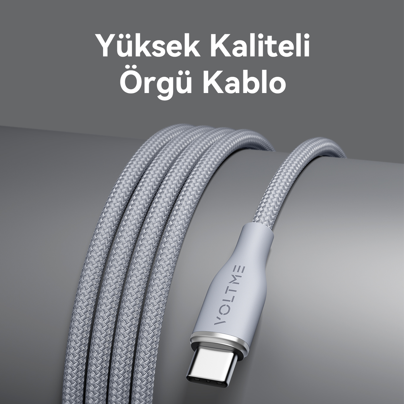 Gri arka plan üzerinde gösterilen, gümüş renkli konektörlü örgülü USB-C kablosu.