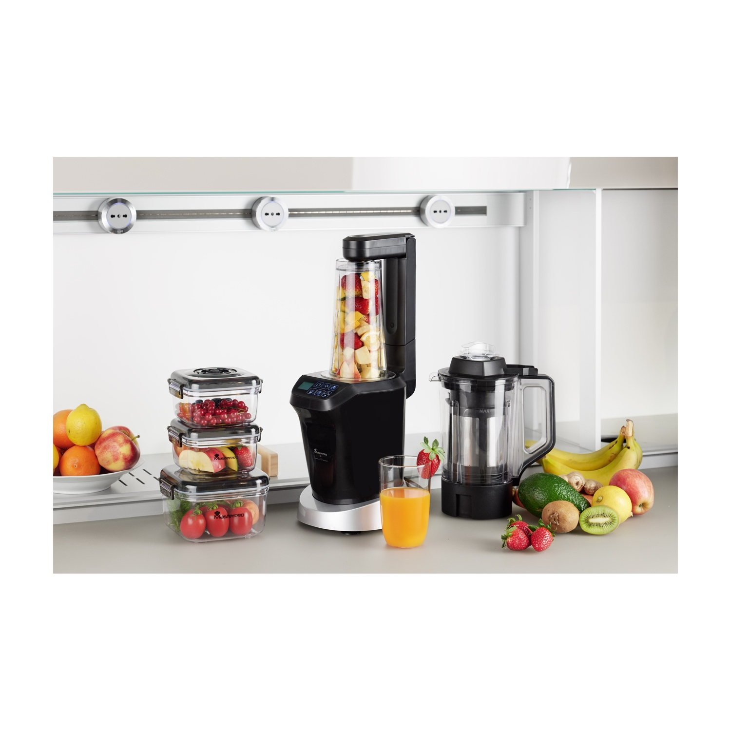 Cucina con frullatore, frutta e contenitori di cibo. Succo d'arancia in un bicchiere.