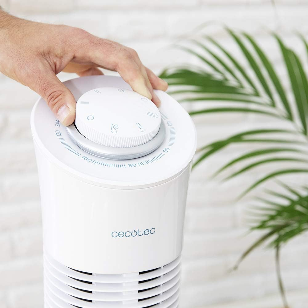 Una mano girando un dial en un ventilador de torre blanco. El ventilador tiene una pantalla digital y la marca 'Cecotec'.