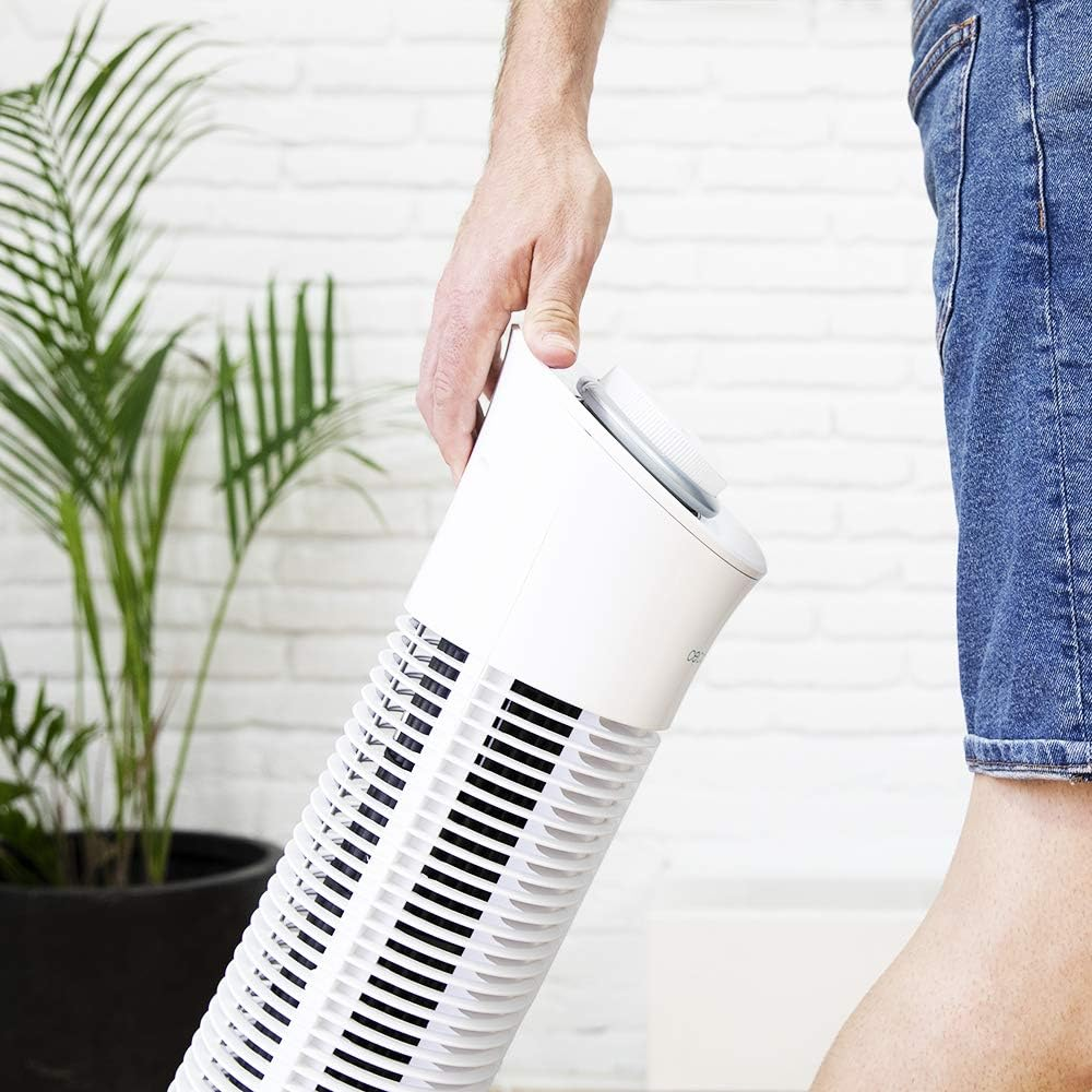Persona sosteniendo un ventilador blanco, vista parcial.