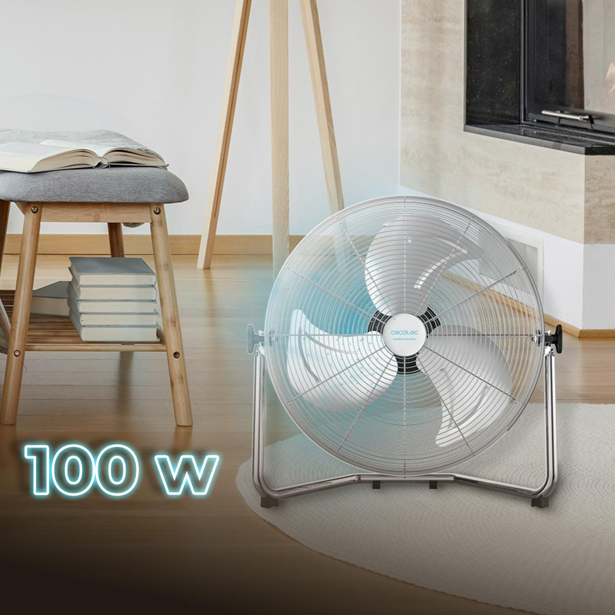 Ventilador de suelo plateado con el texto 100 W. Un libro sobre un taburete. Fondo blanco.