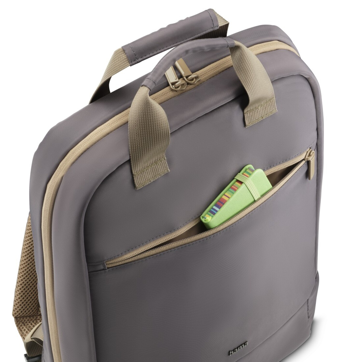 Un sac à dos gris avec une fermeture éclair beige et une trousse verte visible.