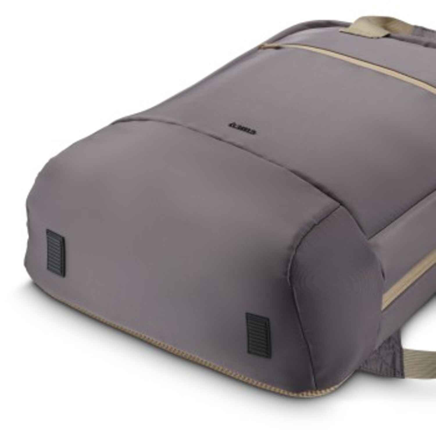 Le bas d'un sac à dos gris avec deux petits pieds rectangulaires noirs et des coutures de couleur beige.