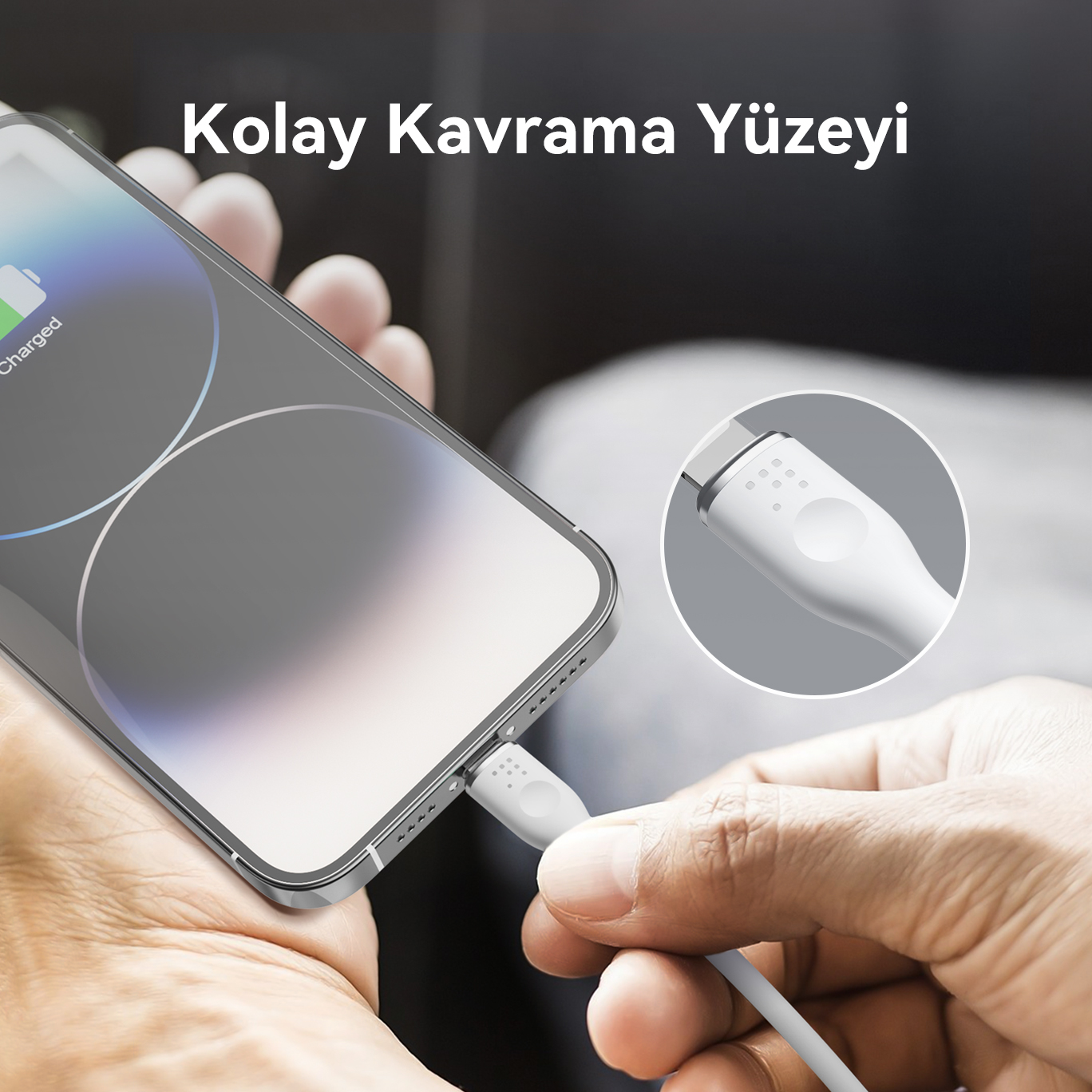 Bir el, beyaz bir USB-C kablosunu telefona takıyor.