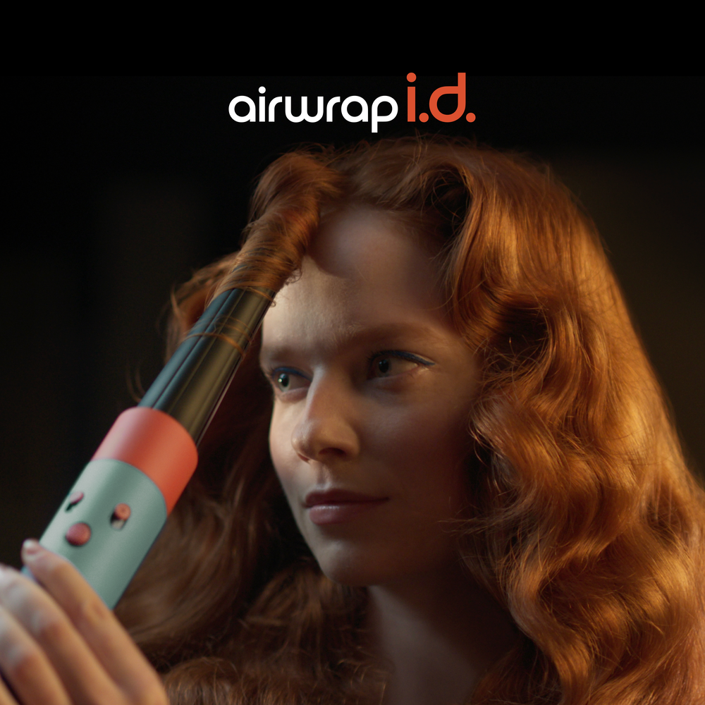Nő Airwrappal göndöríti a haját. Vörös haj, fekete háttér. Airwrap logó.