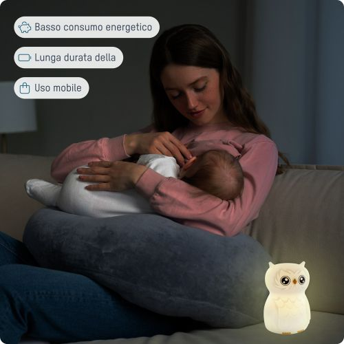 Eine Frau stillt ein Baby mit einem Eulen-Nachtlicht daneben.