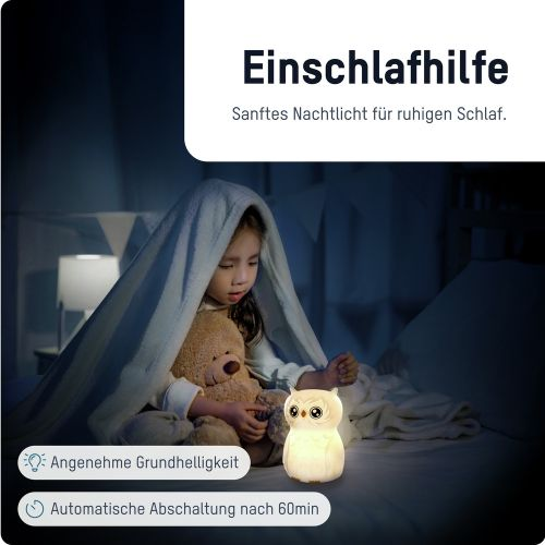 Ein Kind mit Teddybär unter einer Decke und einem Eulen-Nachtlicht.