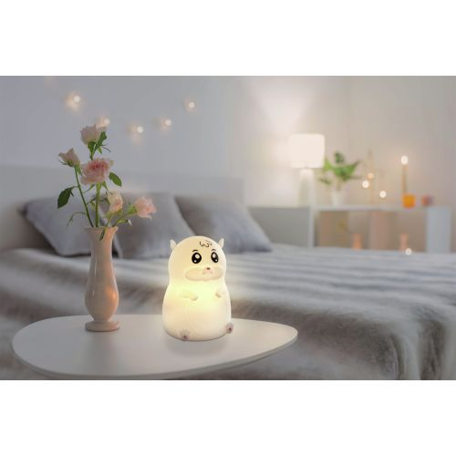 Ein hamsterförmiges Nachtlicht auf einem Tisch mit einer Blumenvase im Hintergrund.