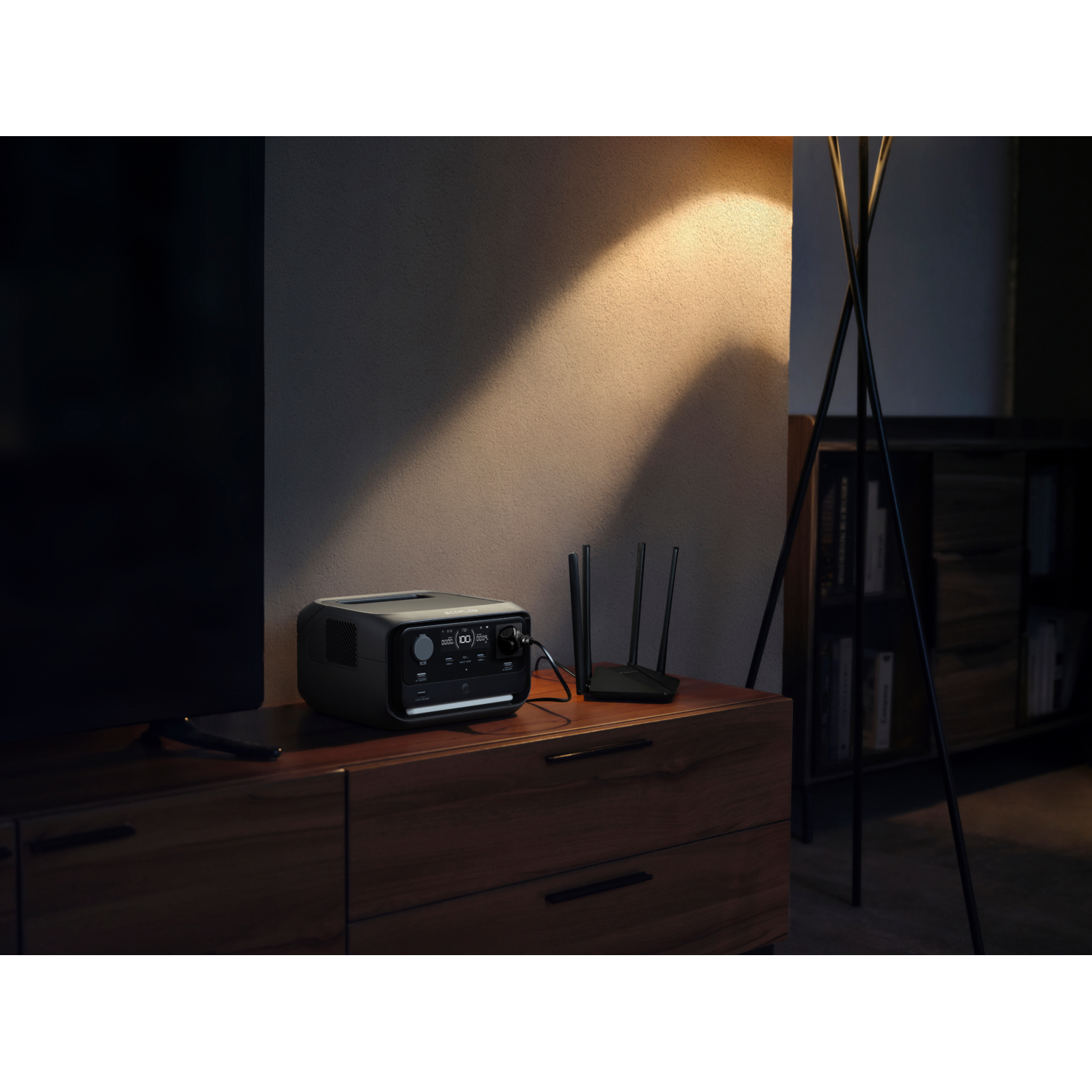 Black power station on a wooden cabinet with a router and lamp.