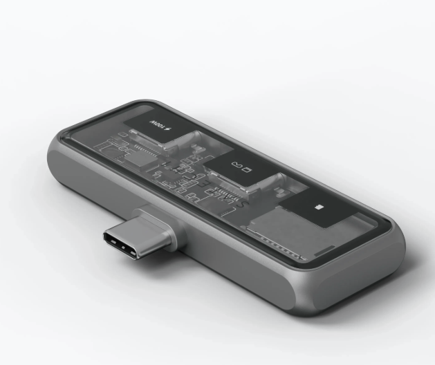 USB-C-Hub, durchscheinende Abdeckung, zeigt interne Komponenten. Silberne Farbe.