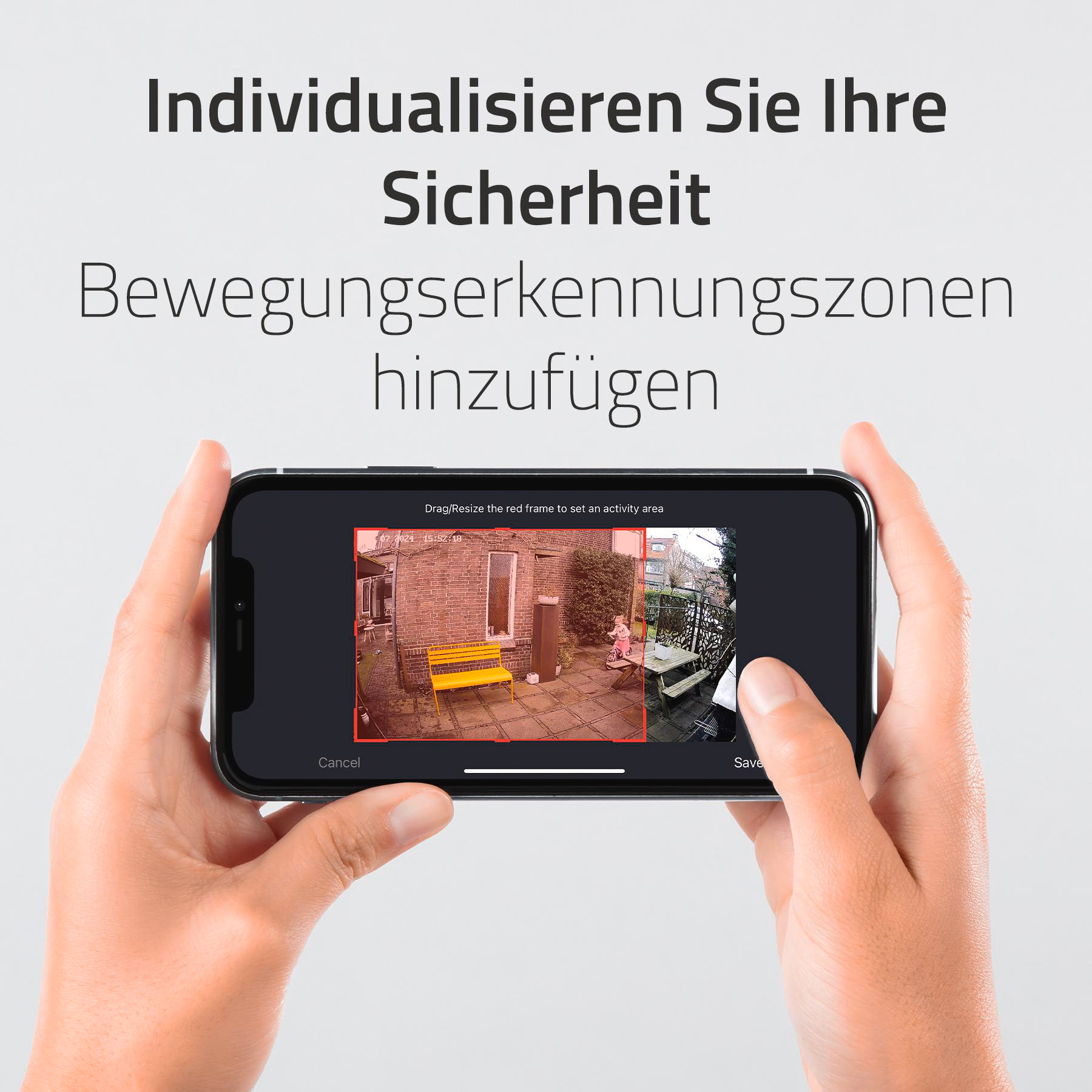 Hände halten ein Telefon, das eine Ansicht des Hinterhofs zeigt.