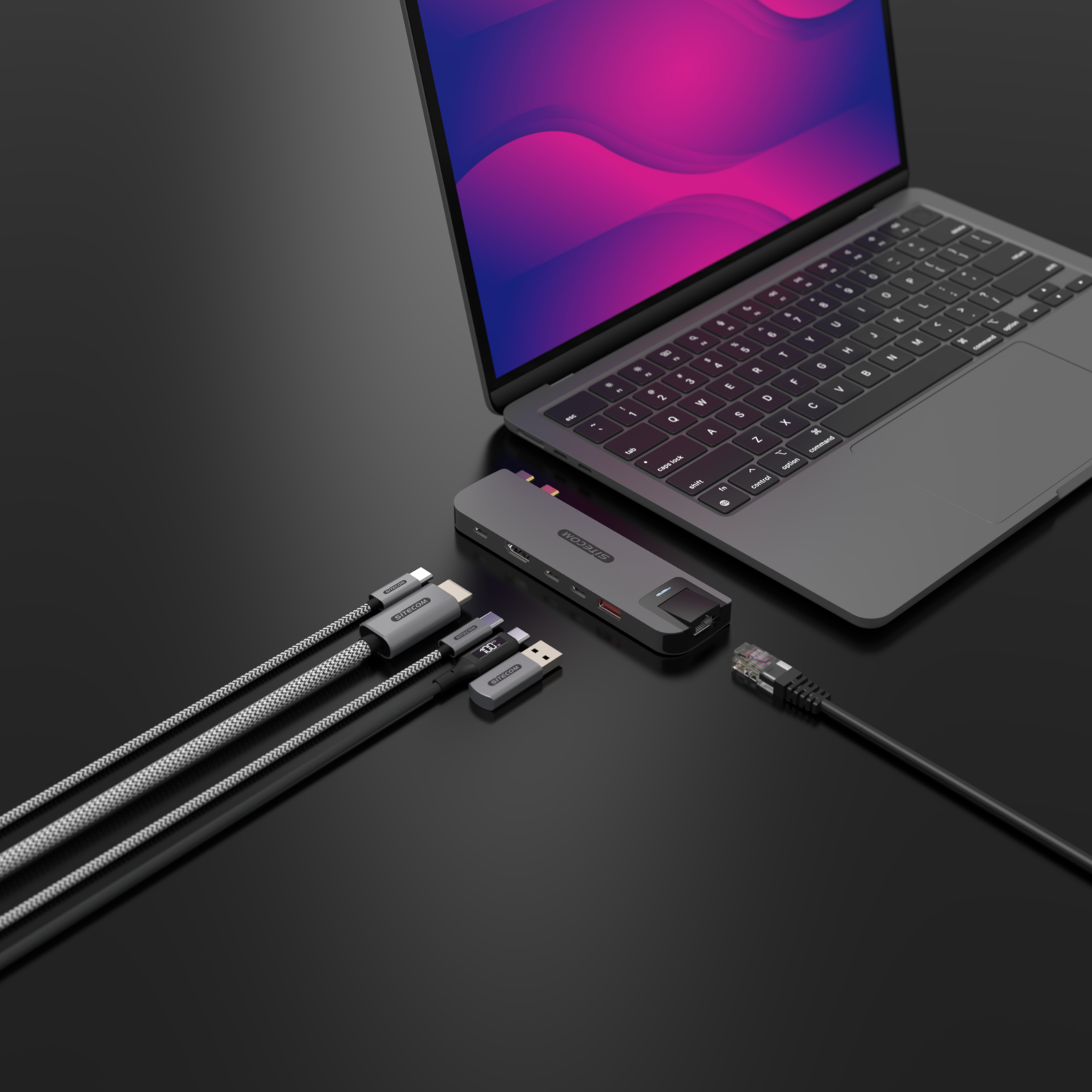 Ordinateur portable, station d'accueil, câbles et clé USB sur surface noire.