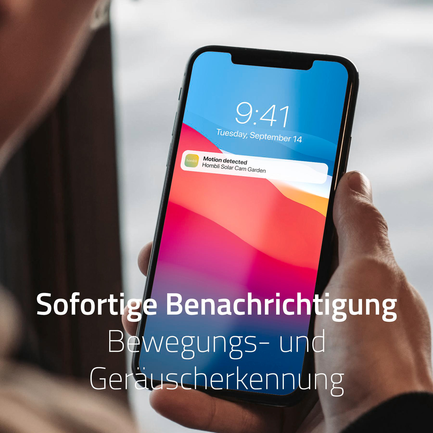 Eine Person hält ein Smartphone mit einer Benachrichtigung, die besagt, dass eine Bewegung erkannt wurde.