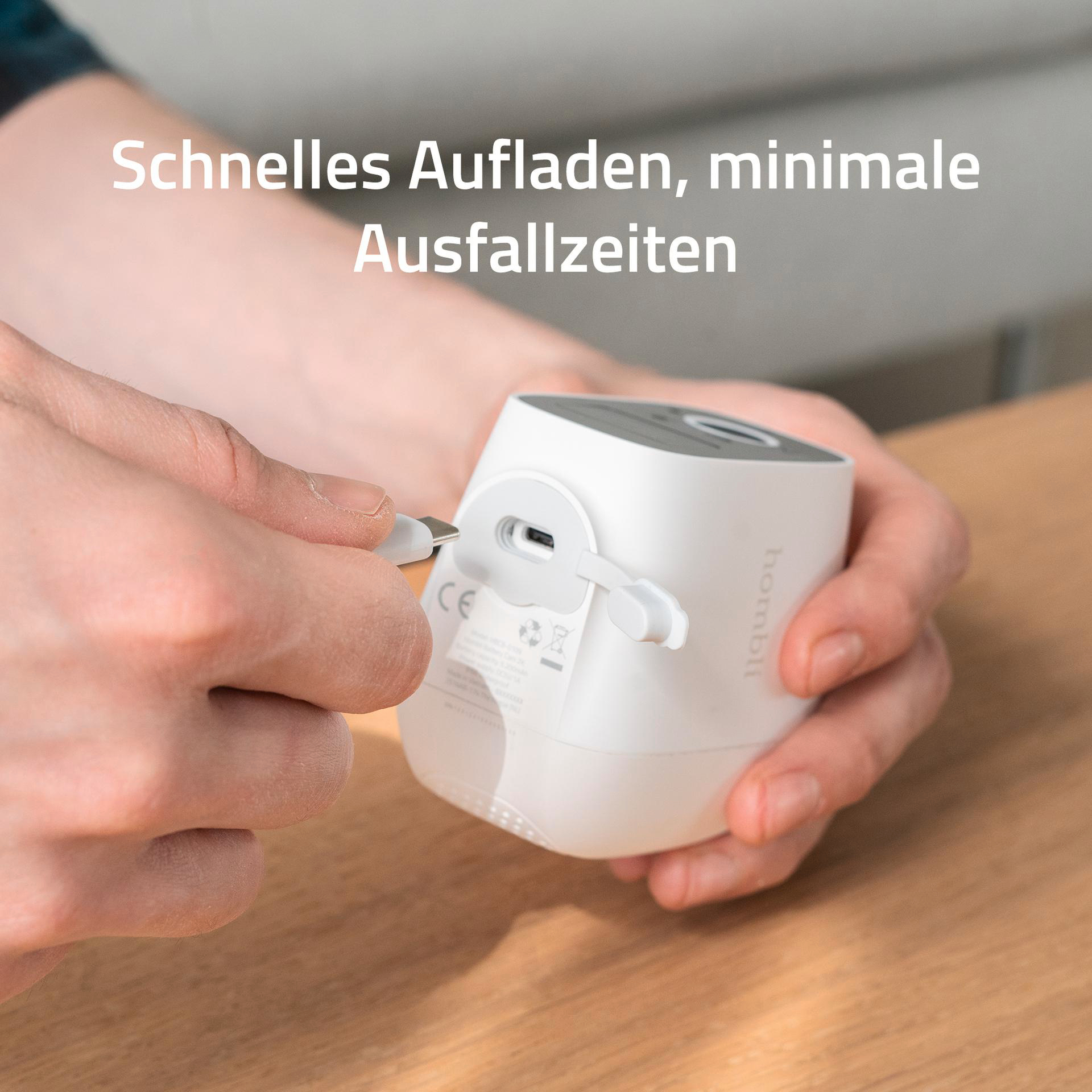 Hände einer Person, die ein weißes Kabel mit einem weißen Gerät verbinden.