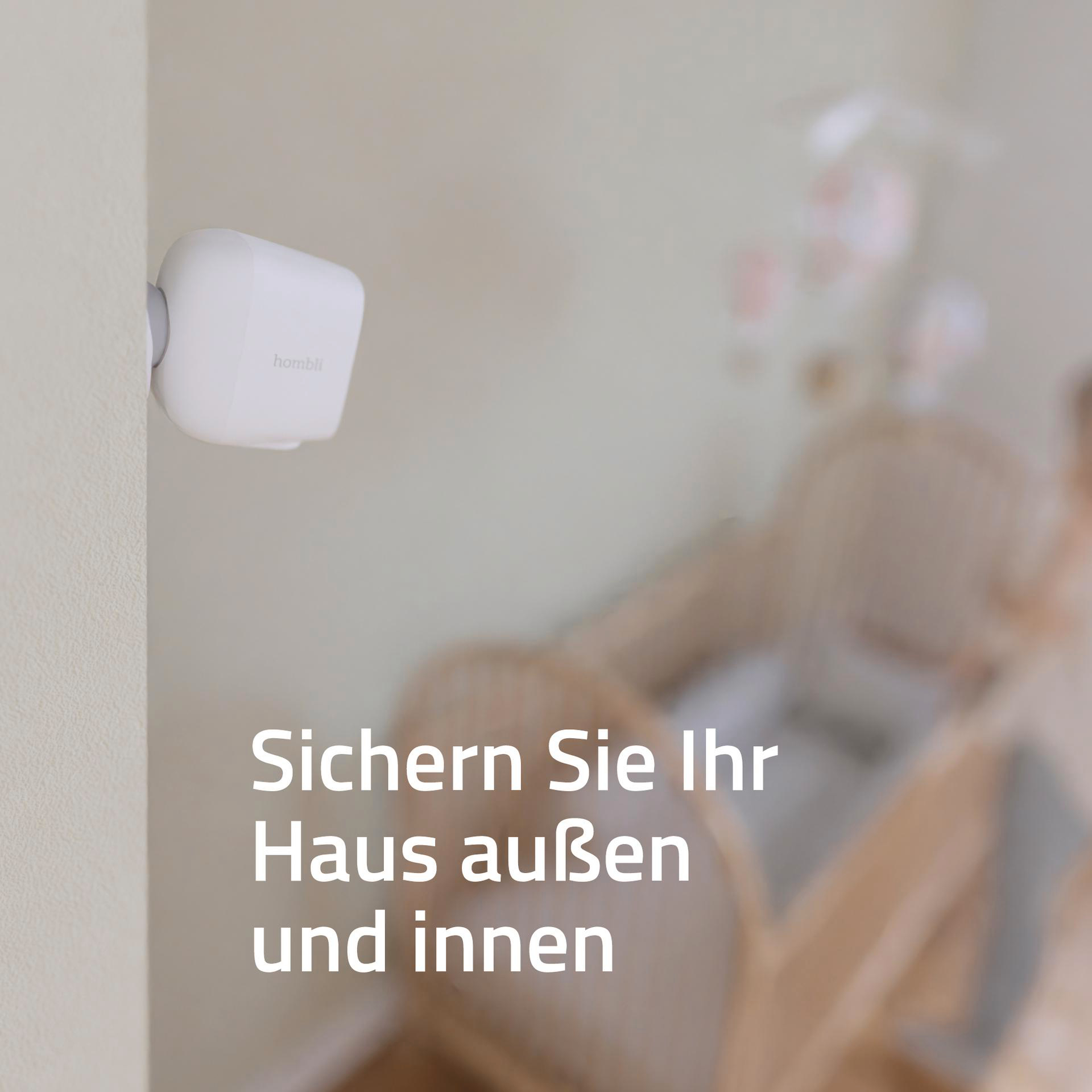 Weiße Überwachungskamera an einer Wand montiert, vor einem verschwommenen Kinderbett. Text: Sichern Sie Ihr Haus innen und außen.