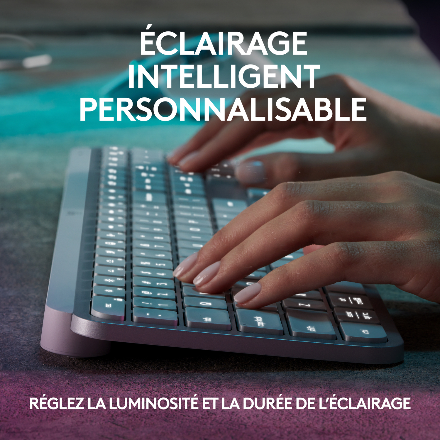 Mains tapant sur un clavier gris avec éclairage personnalisable et intelligent.