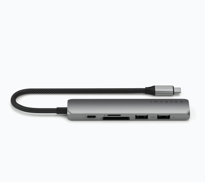 Silberner Satechi-Hub mit angeschlossenem Kabel. Mehrere Anschlüsse sichtbar. USB, SD-Karte.