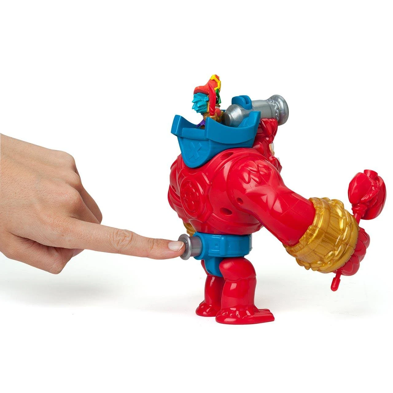 Robot de juguete rojo con detalles azules y dorados. Una mano empuja un botón en el juguete. Una pequeña figura está en la espalda del juguete.
