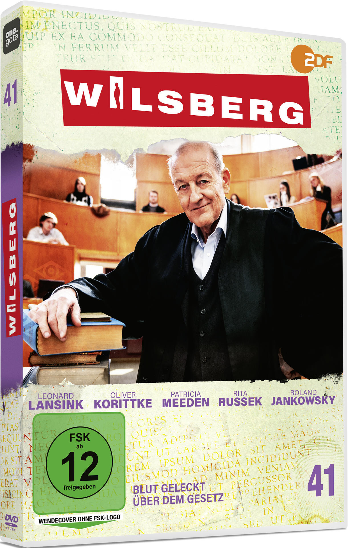Ein Mann im Anzug lächelt, mit einer Küche im Hintergrund.