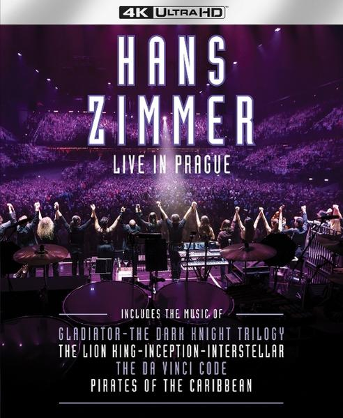 Filmcover für Hans Zimmer Live in Prag. Bühne mit Musikern, Publikum im Hintergrund, lila Beleuchtung.