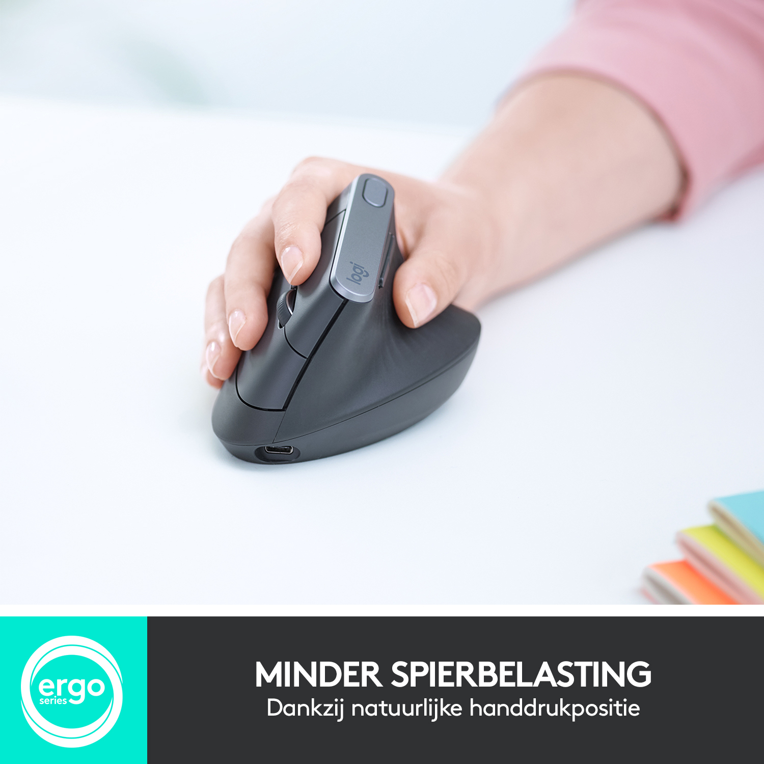 A hand holding a black vertical mouse on a white surface with a logo and text.