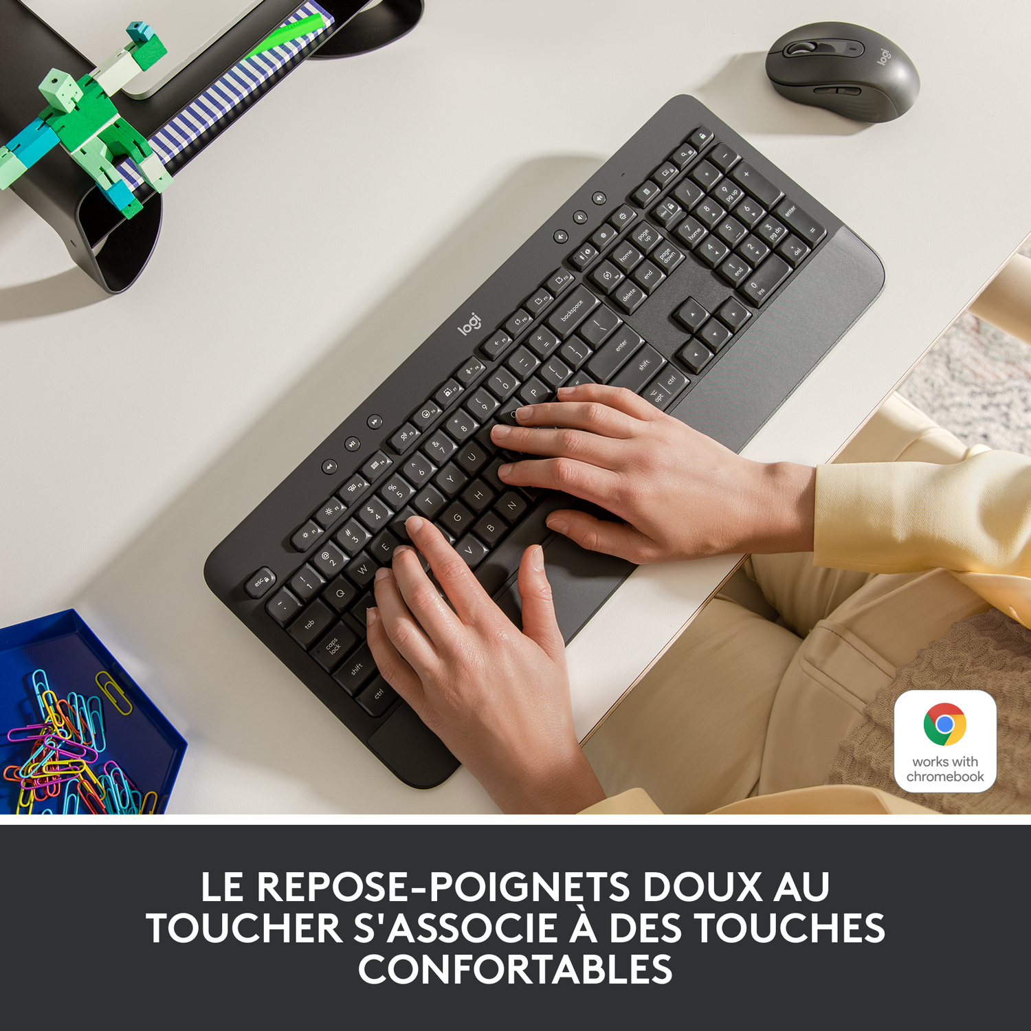 Un clavier et une souris sur une table blanche avec un plateau bleu de trombones et du texte.