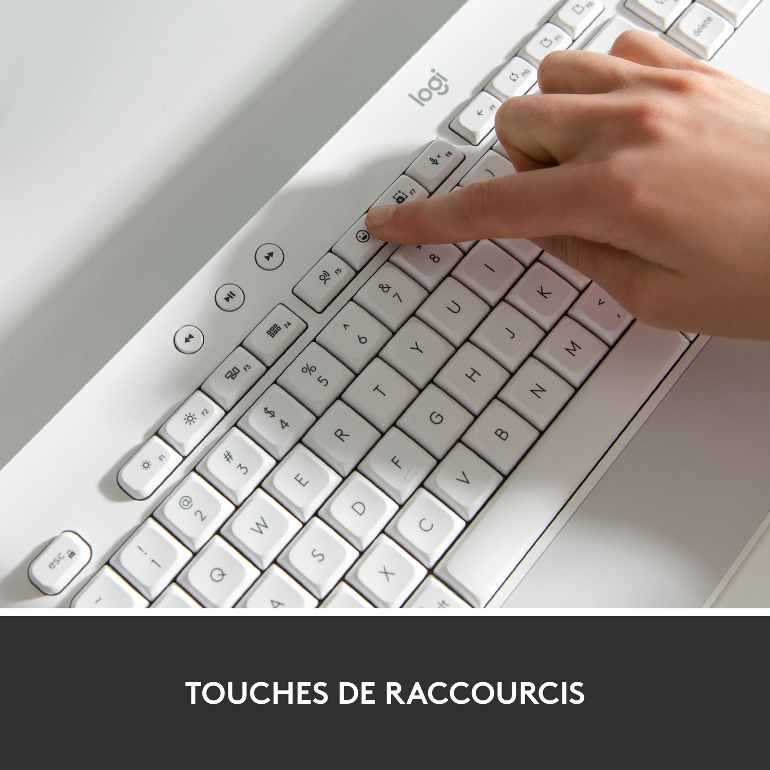 Le doigt d'une personne appuie sur une touche d'un clavier blanc. Texte : Touches de raccourci.
