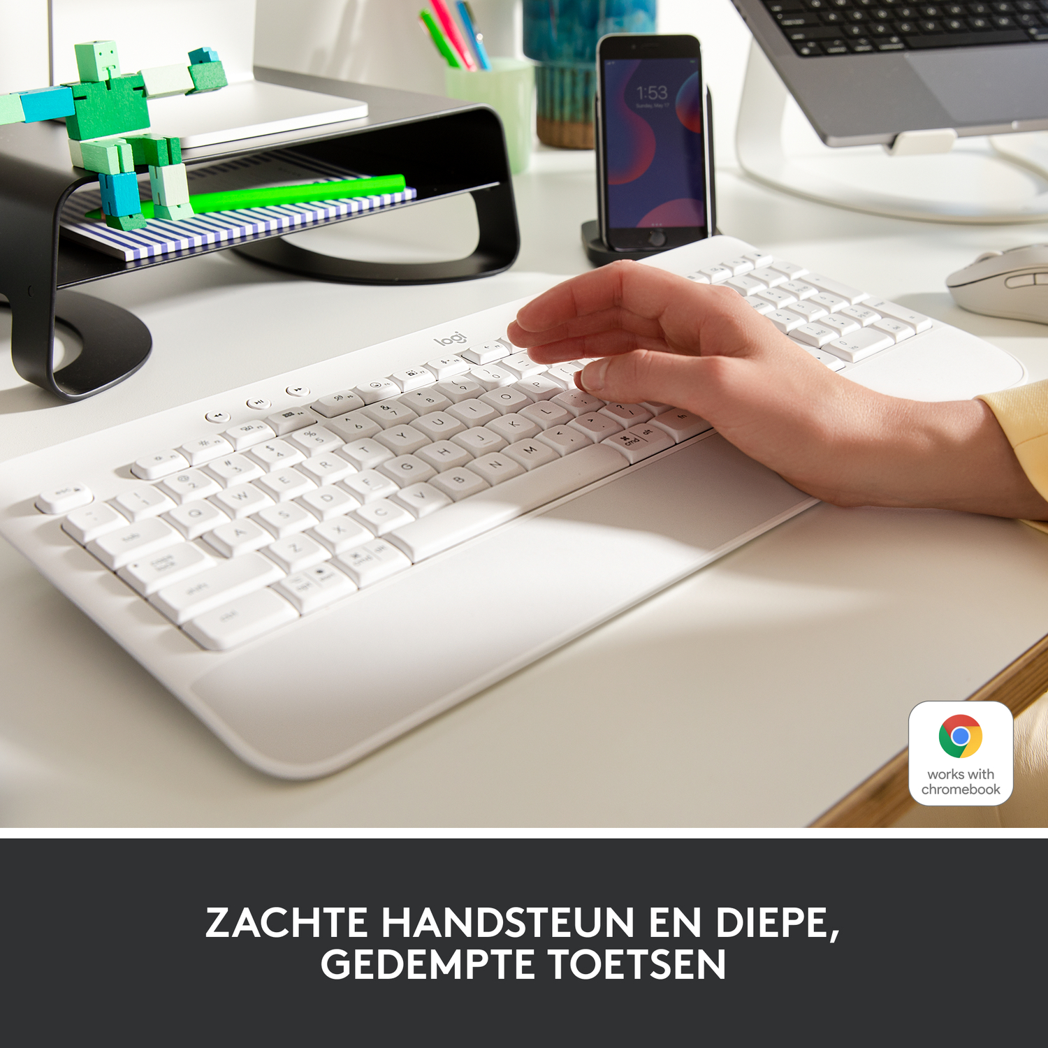 De hand van een persoon rust op een toetsenbord met een muis en een monitor. Tekst: Zachte polssteun met comfortabele toetsen.