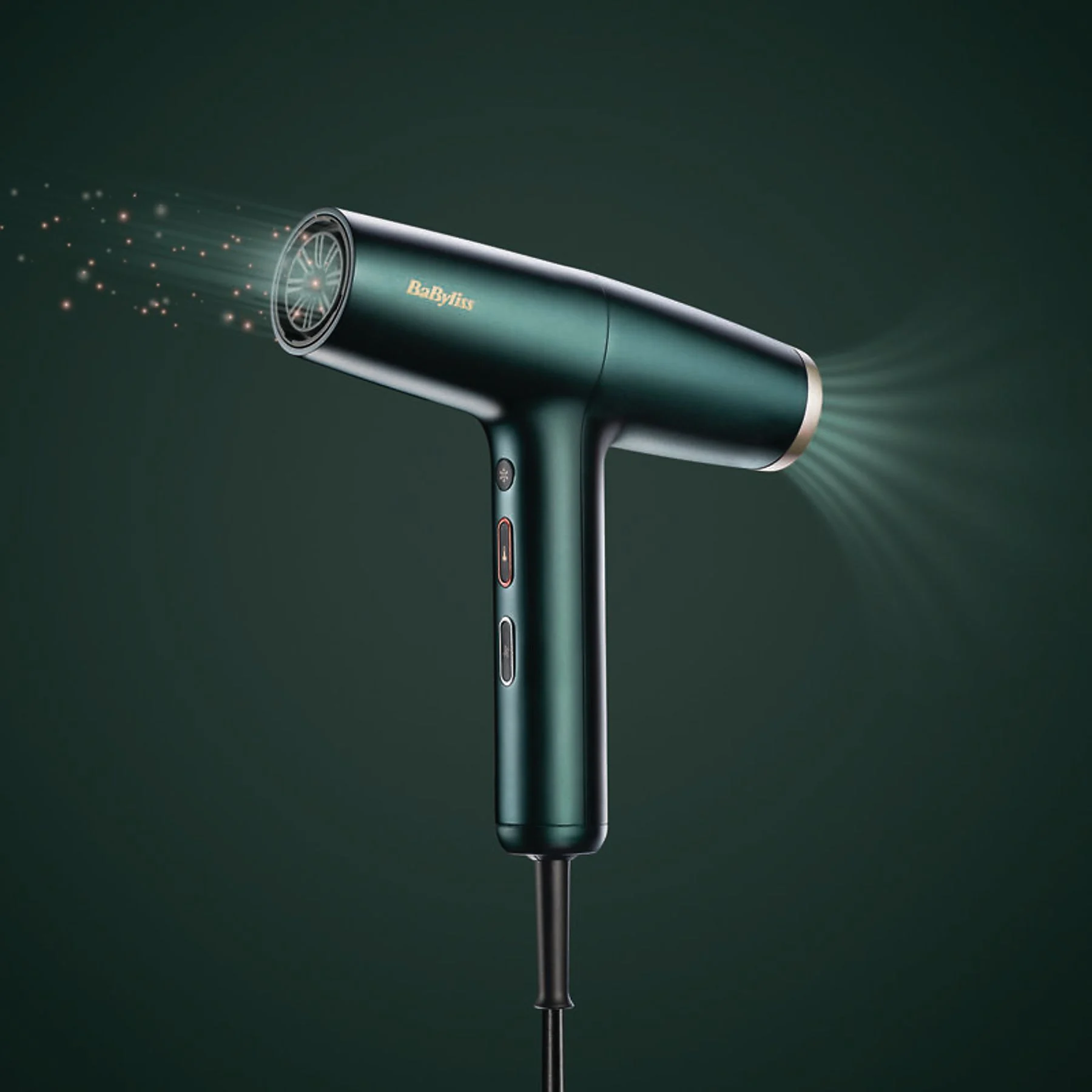 Zöld BaByliss hajszárító. Fény sugarak jönnek a fúvókából.