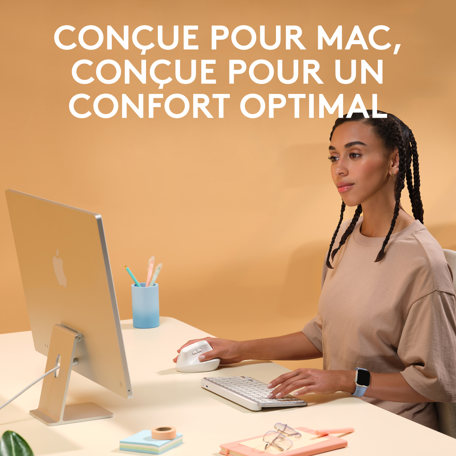 Une femme est assise à un bureau et utilise un ordinateur, avec une souris et un clavier.
