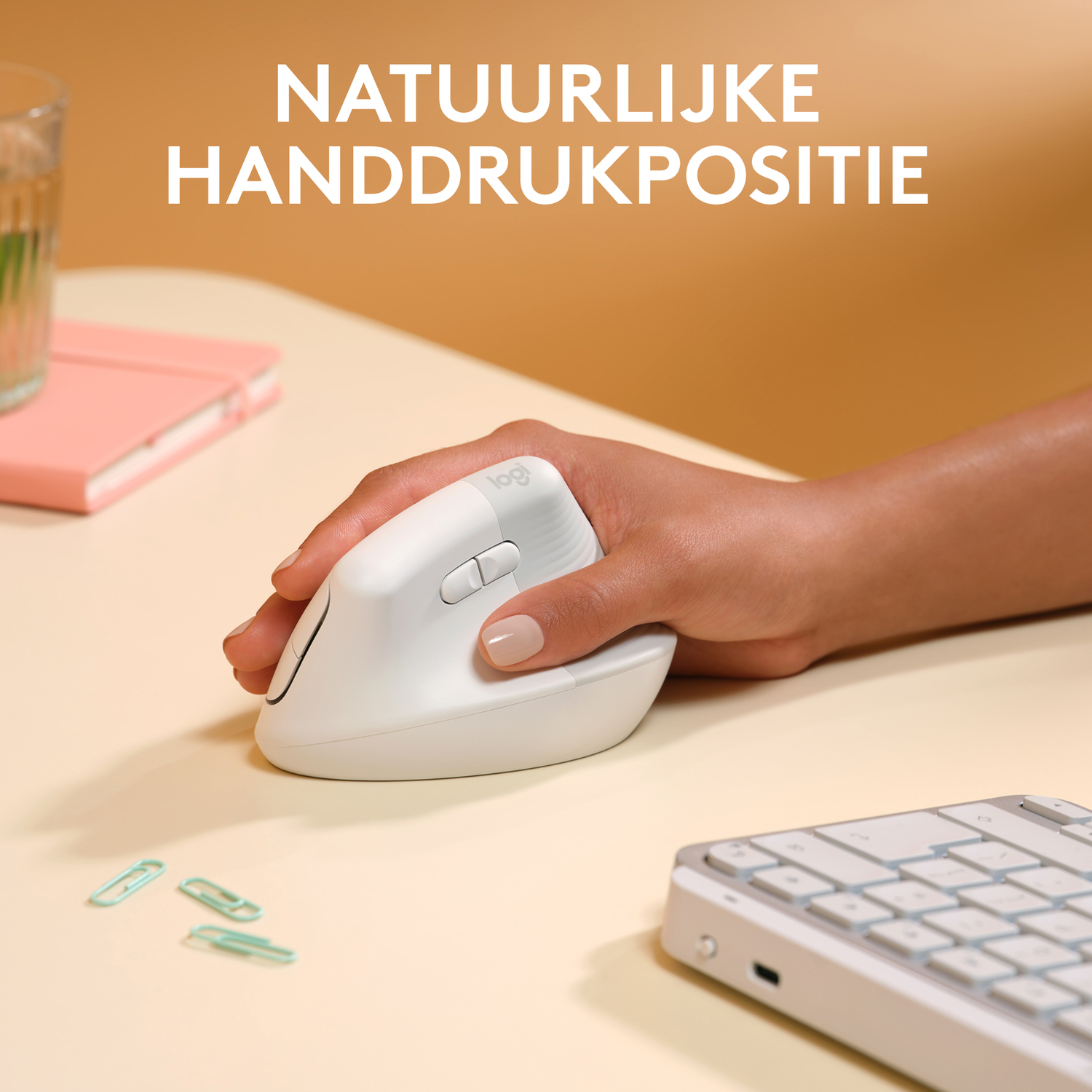 De hand van een persoon rust op een witte ergonomische muis.