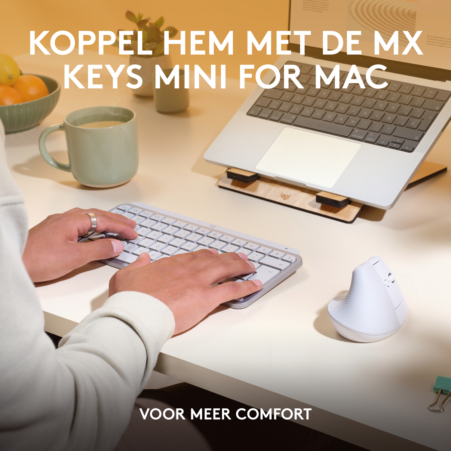 Man gebruikt toetsenbord en muis op een bureau naast een laptop.
