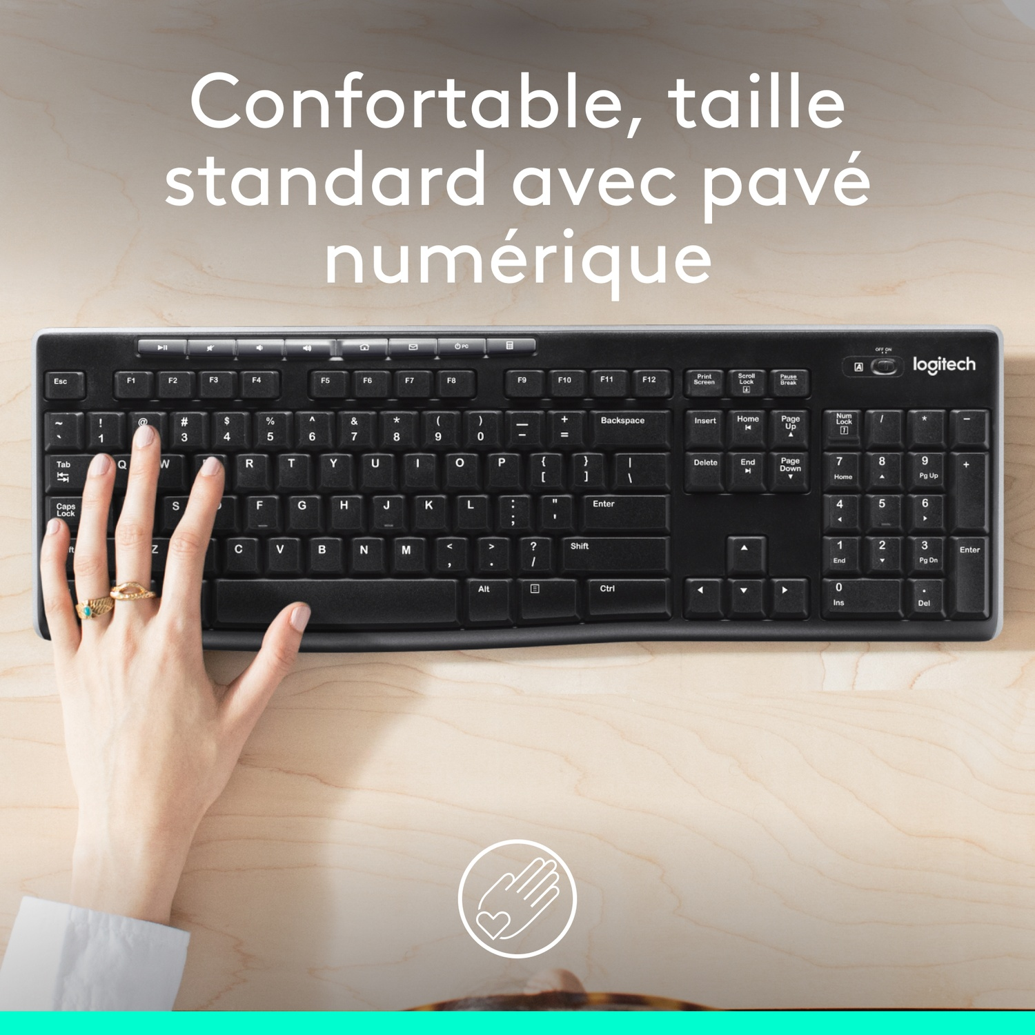 Clavier noir avec une main dessus, sur un bureau en bois. Confortable et de taille standard.