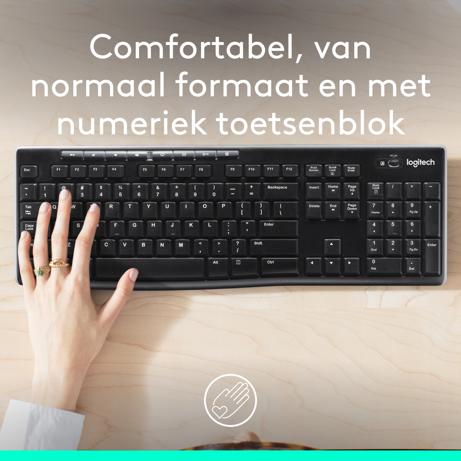 Black keyboard with a hand on it, on a wooden desk. Comfortable and standard size with number pad.