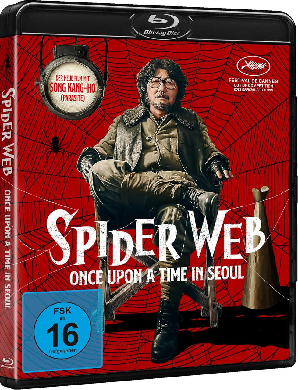 Blu-ray-Cover von 'Spider Web'. Ein Mann sitzt auf einem Stuhl vor rotem Spinnennetz-Hintergrund. Text: 'Spider Web Once Upon a Time in Seoul.'