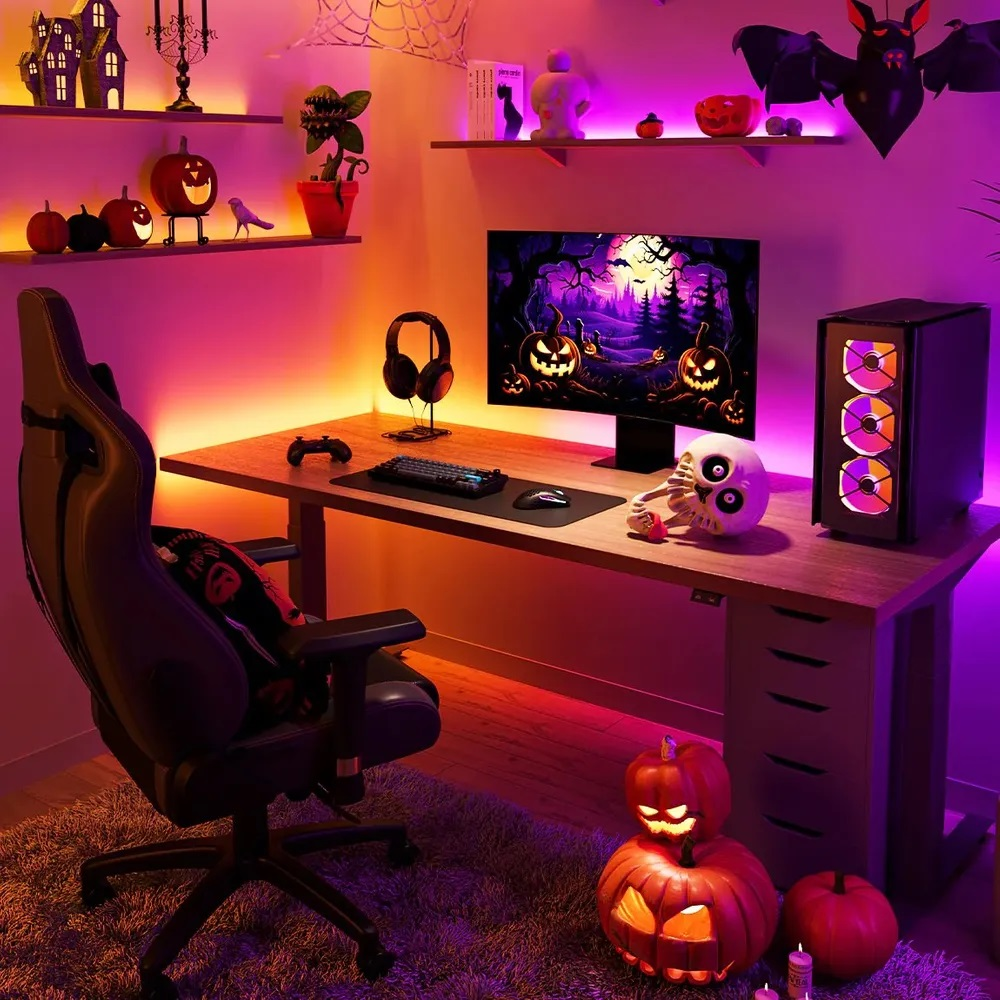 Konfiguracja do gier w stylu Halloween z dyniami, światłami i czaszką. Monitor wyświetla straszną scenę.